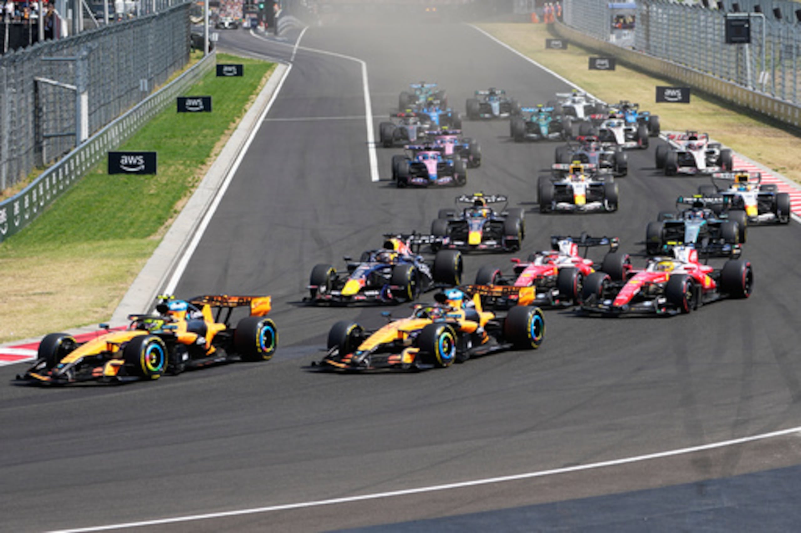 El piloto británico de McLaren, Lando Norris (a la izquierda), lidera la carrera tras la salida del Gran Premio de Hungría de Fórmula 1, celebrado en el circuito de Hungaroring, en Mogyorod, cerca de Budapest (Hungría), el domingo 26 de julio de 2026. (Foto AP/Darko Bandic)