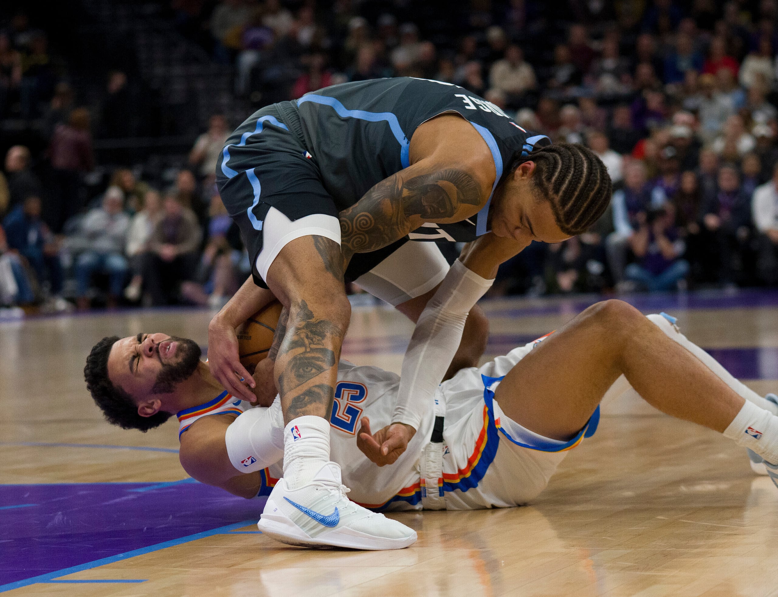 Keyonte George, escolta del Jazz de Utah, arriba, y Ajay Mitchell (25), escolta del Thunder de Oklahoma City, luchan por el balón durante la primera mitad de un juego de baloncesto de la NBA el domingo 7 de diciembre de 2025, en Salt Lake City. (AP Photo/Bethany Baker)