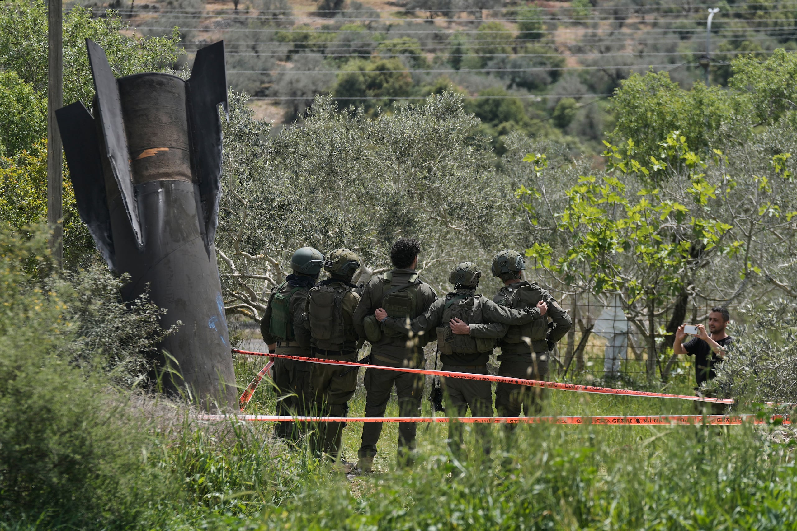 Soldados israelíes se toman una foto frente a los restos de un misil iraní que cayó el martes 24 de marzo de 2026, en el poblado de Kifl Haris, Cisjordania. (AP Foto/Majdi Mohammed)
