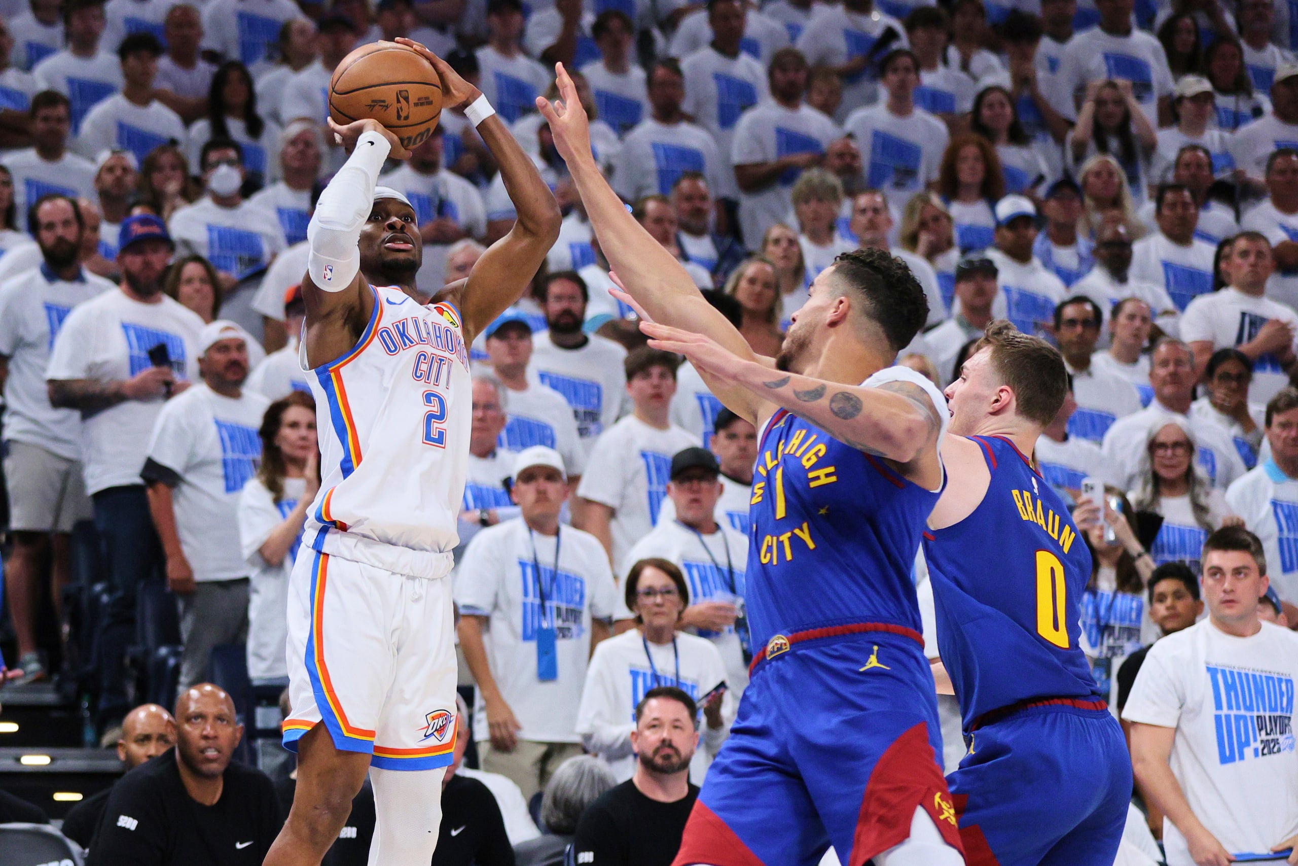 Shai Gilgeous-Alexander, del Thunder de Oklahoma City, dispara sobre Michael Porter Jr. y Christian Braun, de los Nuggets de Denver, en la segunda mitad del quinto juego de una serie de playoffs de segunda ronda de la NBA.