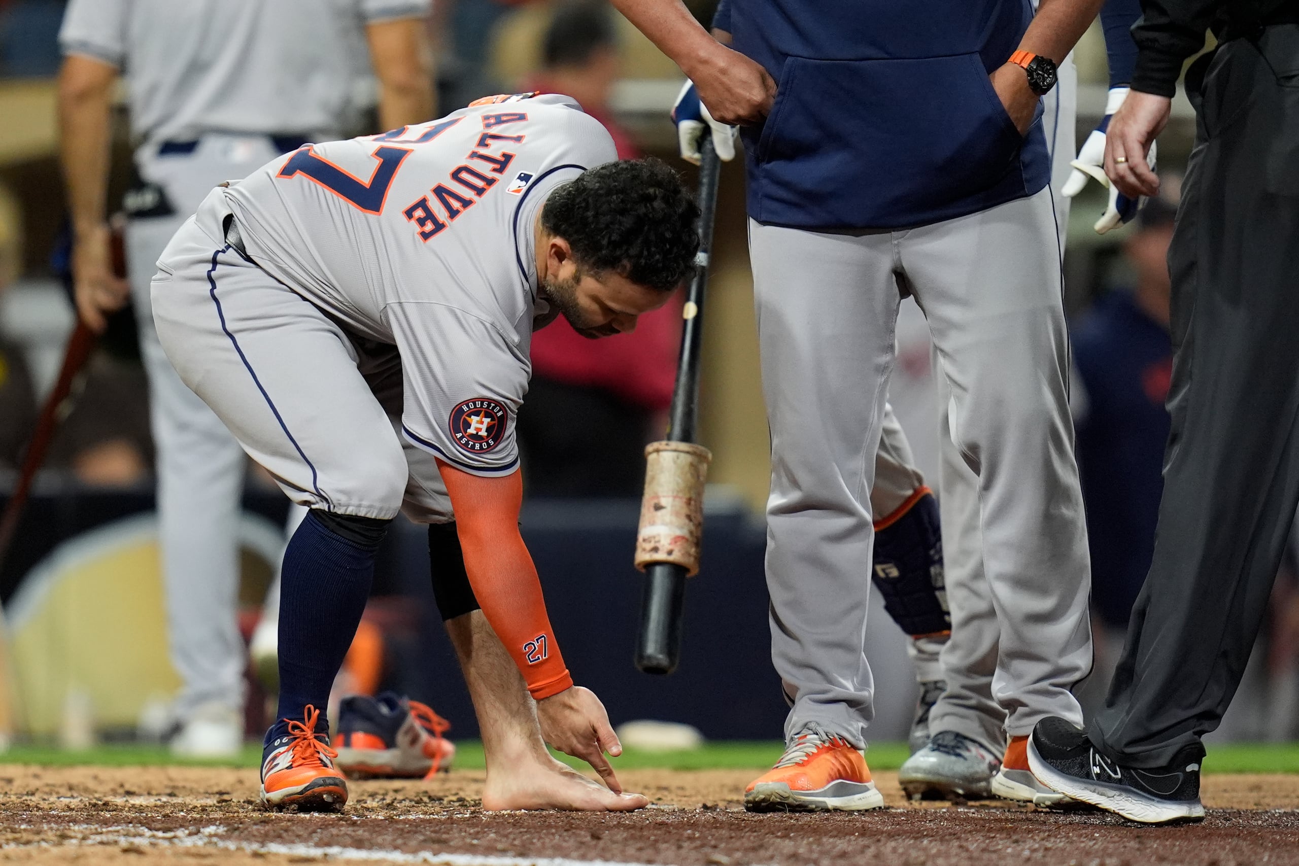 El venezolano José Altuve señala hacia su pie izquierdo tras quitarse el zapato y la media en el juego del martes 17 de septiembre de 2024, ante los Padres de San Diego (AP Foto/Gregory Bull)