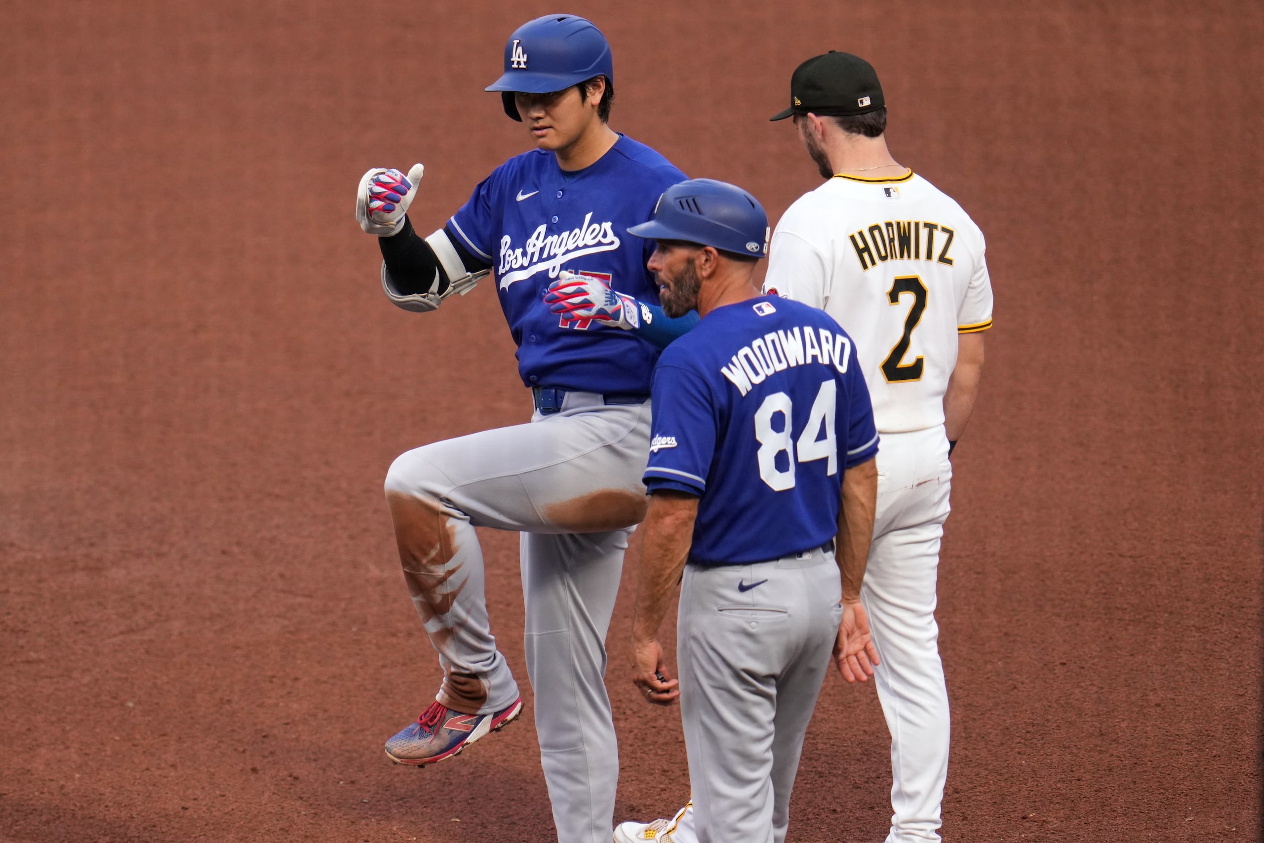 Shohei Ohtani, de los Dodgers de Los Ángeles, celebra en la primera base tras conectar un sencillo ante los Pirates.