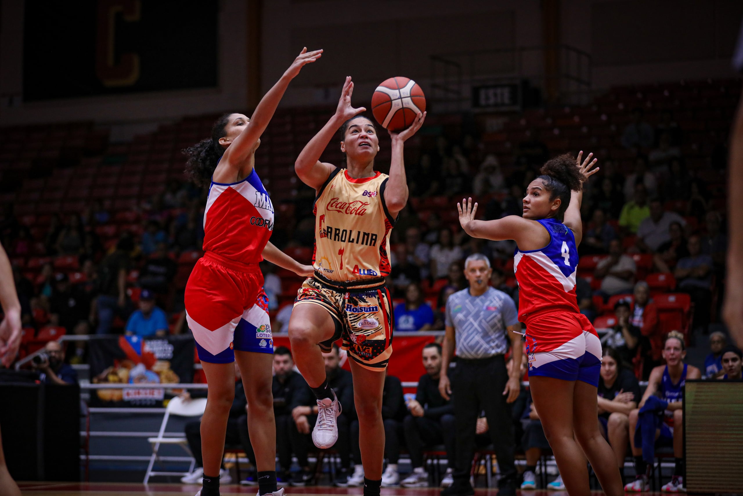 Tayra Meléndez ataca el canasto ante la defensa de Isalys Quiñones.