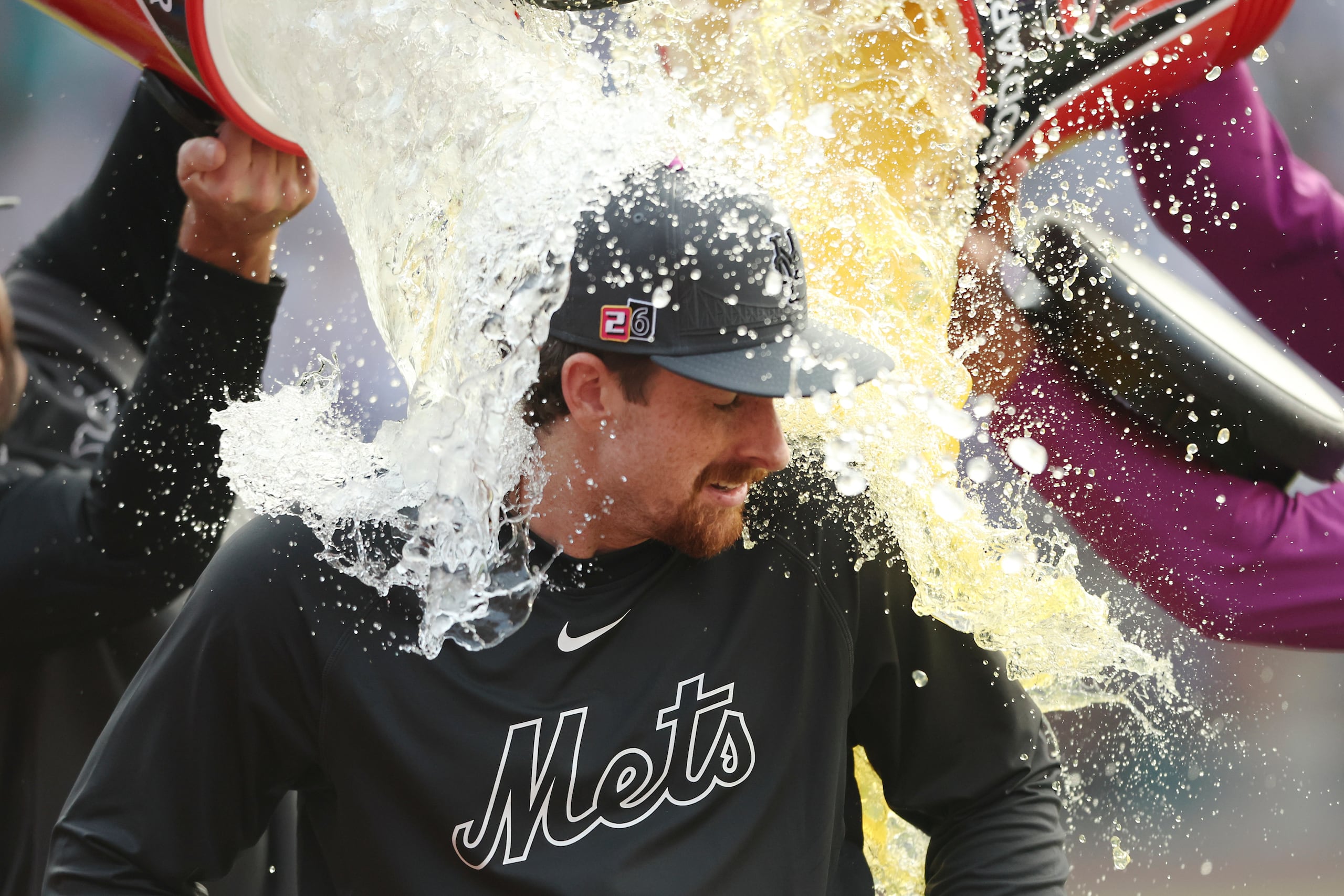 Nolan McLean, lanzador de los Mets de Nueva York, es empapado con la hielera tras ganar el juego del sábado ante los Marineros de Seattle.