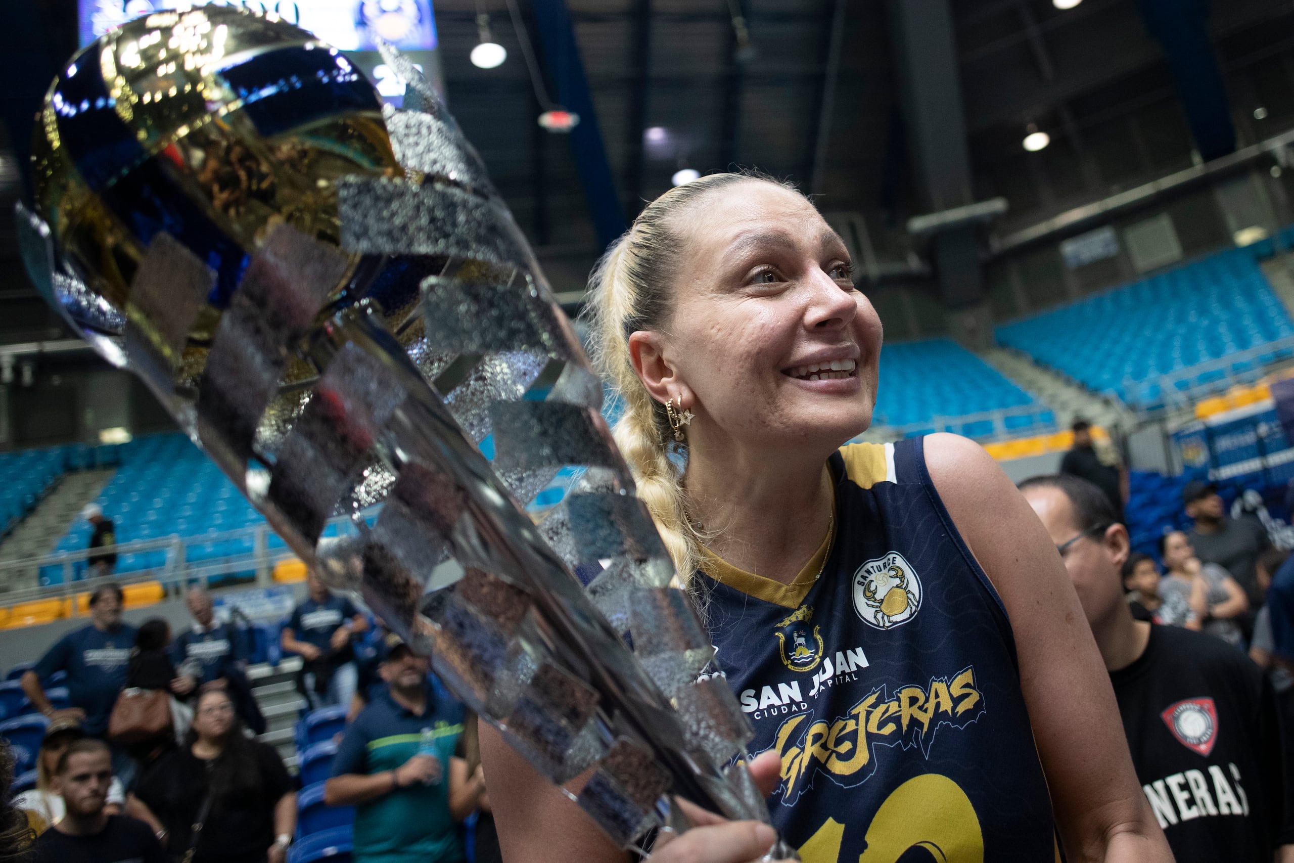 La turca de las Cangrejeras, Yeliz Baza, sostiene el trofeo de campeonas del Voleibol Superior este lunes en Manatí.