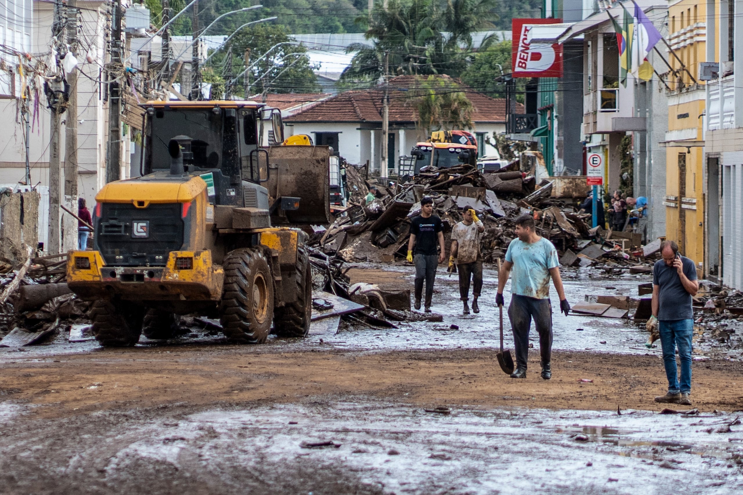 Fotografía cedida por el Gobierno del estado de Rio Grande do Sul que muestra a unas personas junto a un vehículo de maquinaria pesada mientras despejan una calle inundada por las torrenciales lluvias, en Muçum, estado de Rio Grande do Sul (Brasil). EFE/ Mauricio Tonetto/gobierno Del Estado De Rio Grande Do Sul