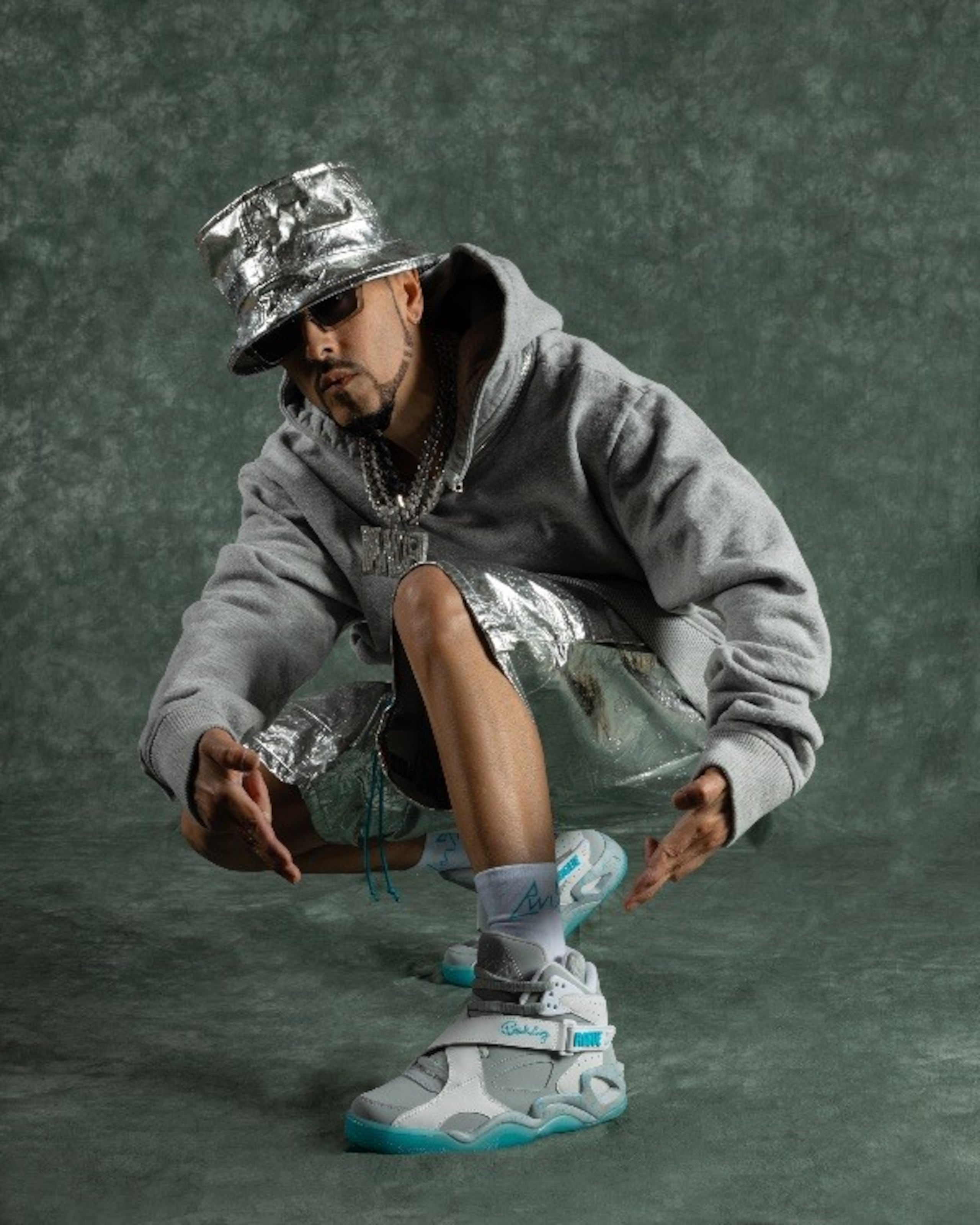 Esta colaboración entre las estrellas, marca la primera vez que un modelo de zapatillas Ewing incluye un folleto en español.