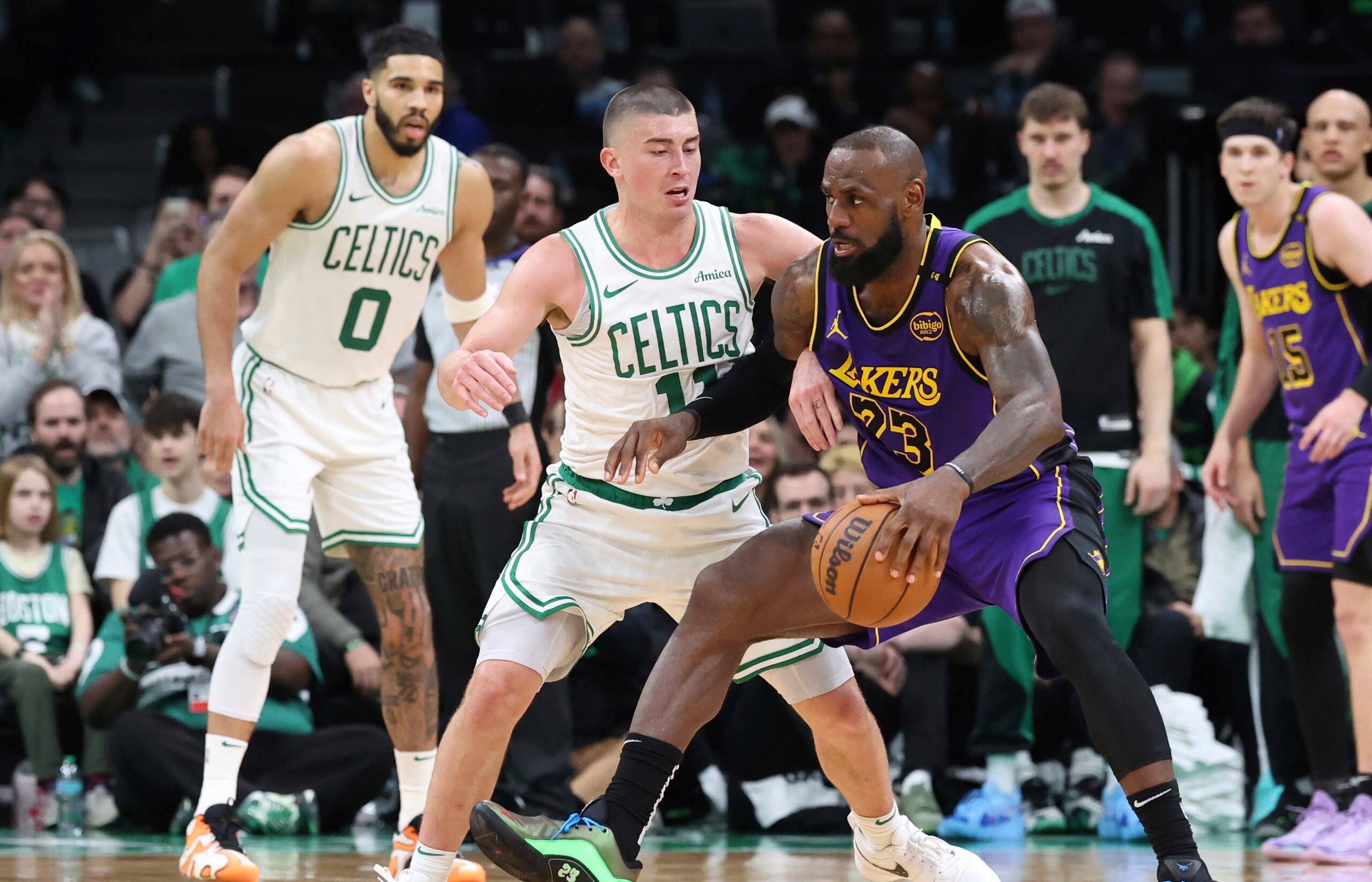 LeBron James (23), de los Lakers de Los Ángeles, defiende la posesión del balón ante la presión defensiva de Payton Pritchard (11), de los Celtics de Boston, durante la segunda mitad del juego de baloncesto de la NBA, el sábado 8 de marzo de 2025, en Boston.