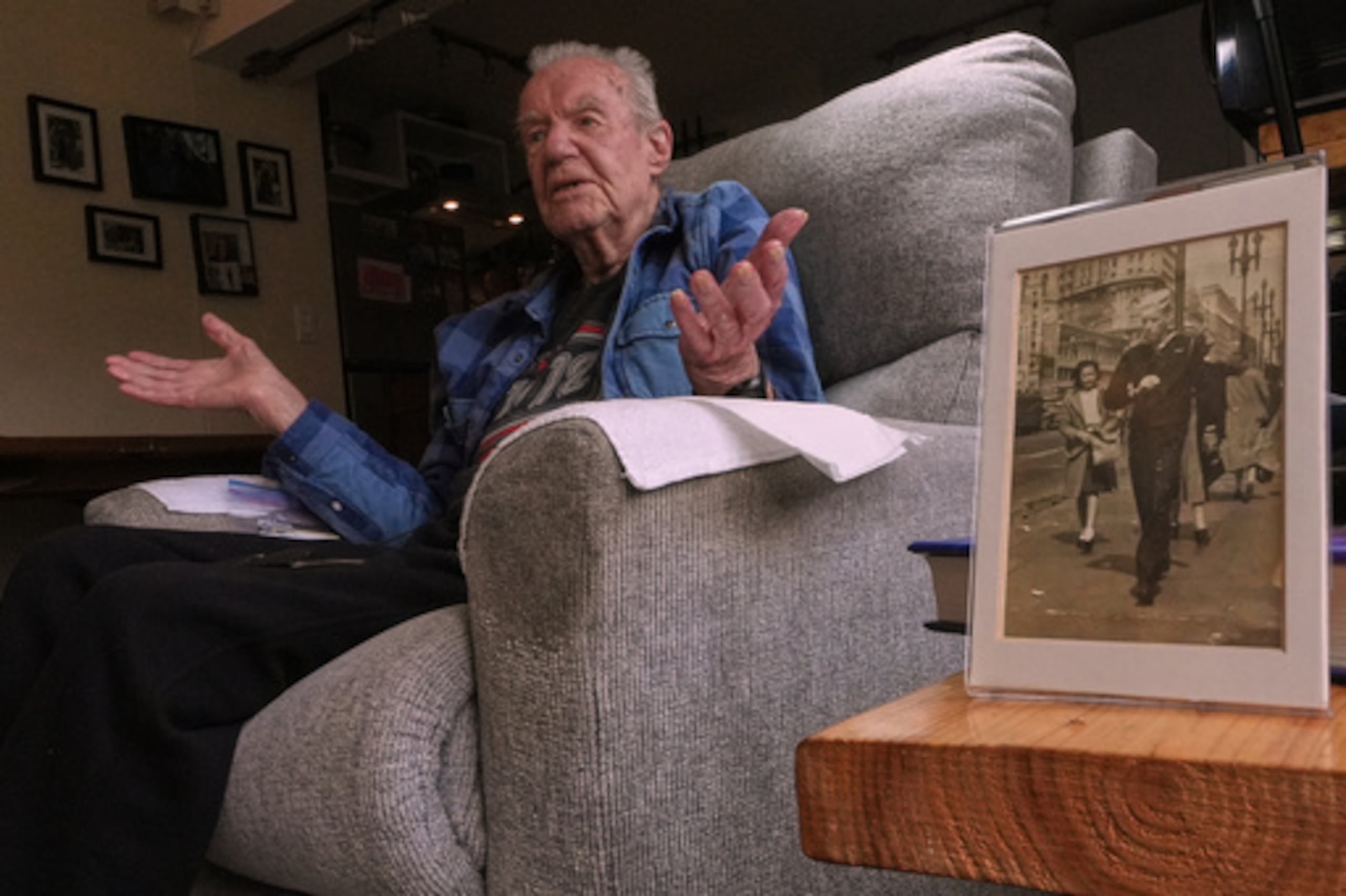 Freeman K. Johnson, un superviviente de Pearl Harbor de 106 años, gesticula durante una entrevista, junto a una fotografía suya de permiso en 1943, en su casa el 6 de mayo de 2026, en Centerville, Massachusetts (AP Photo/Charles Krupa).