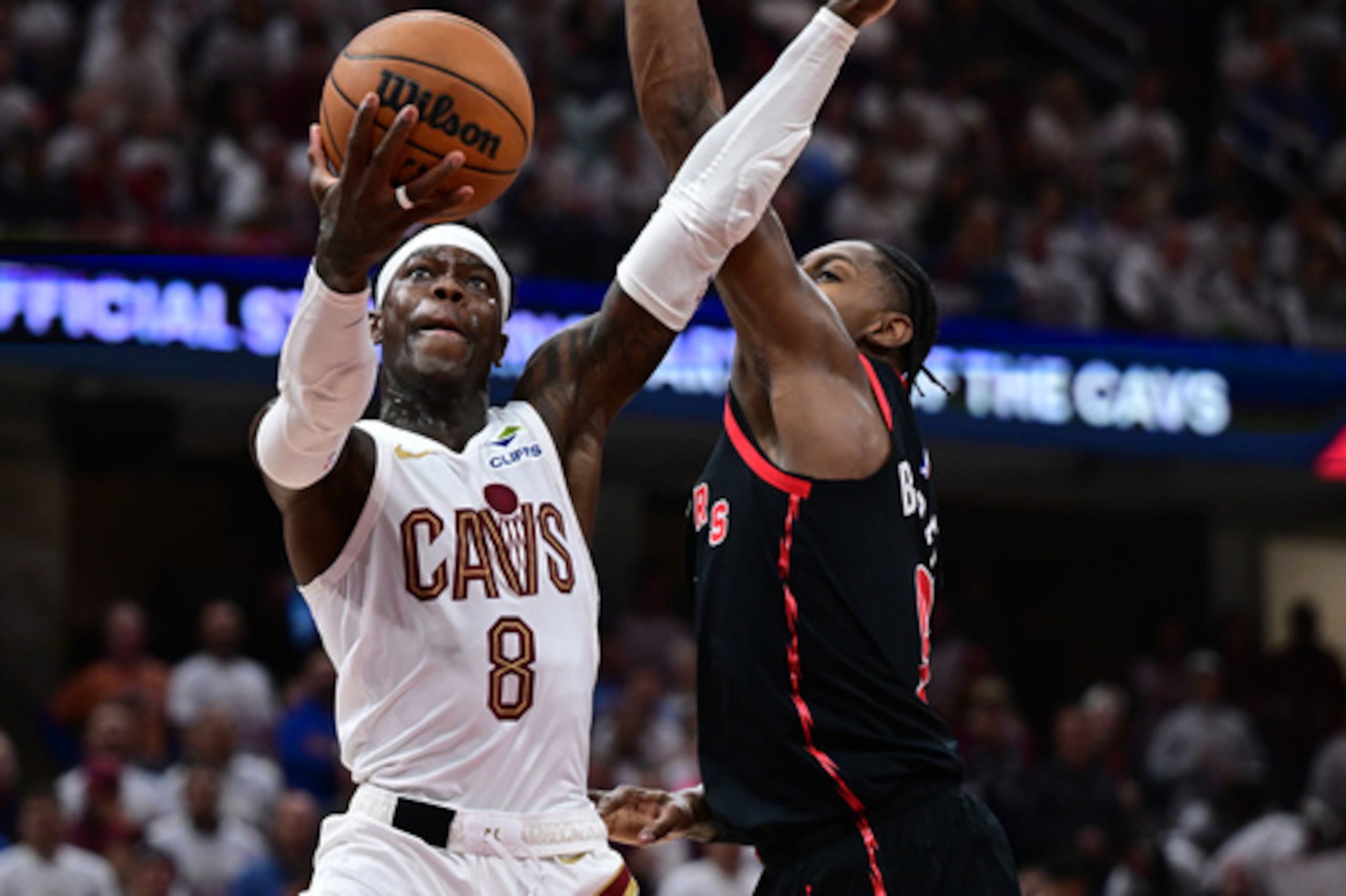 El escolta de los Cleveland Cavaliers, Dennis Schroder, va hacia la canasta contra el alero de los Toronto Raptors, RJ Barrett, durante la segunda mitad del quinto partido de la primera ronda de los playoffs de baloncesto de la NBA, el miércoles 29 de abril de 2026, en Cleveland. (AP Photo/David Dermer)