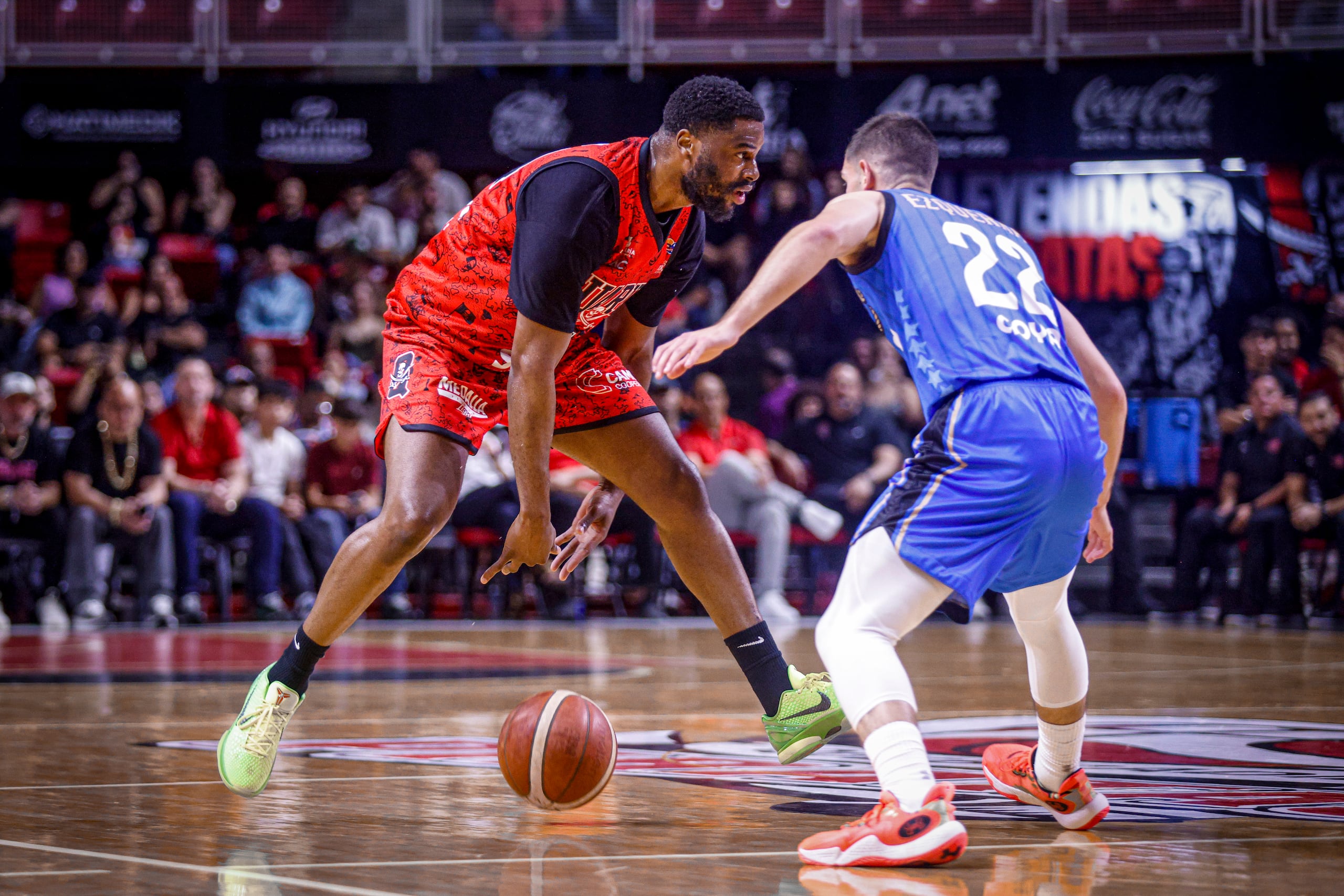 Emmanuel Mudiay, refuerzo de los Piratas de Quebradillas, maneja el balón ante la defensa de Javier Ezquerra, de los Vaqueros de Bayamón.