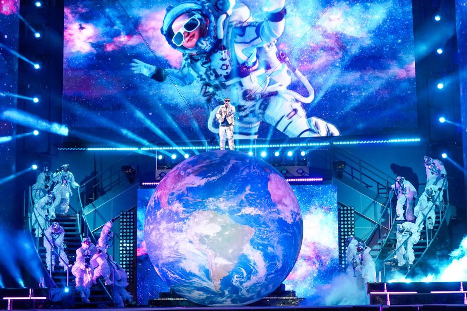 La escenografía de Yankee fue muy vistosa y colorida, al incluir un globo que representaba el planeta Tierra, imágenes alusivas a la galaxia y bailarines al fondo de la tarima.