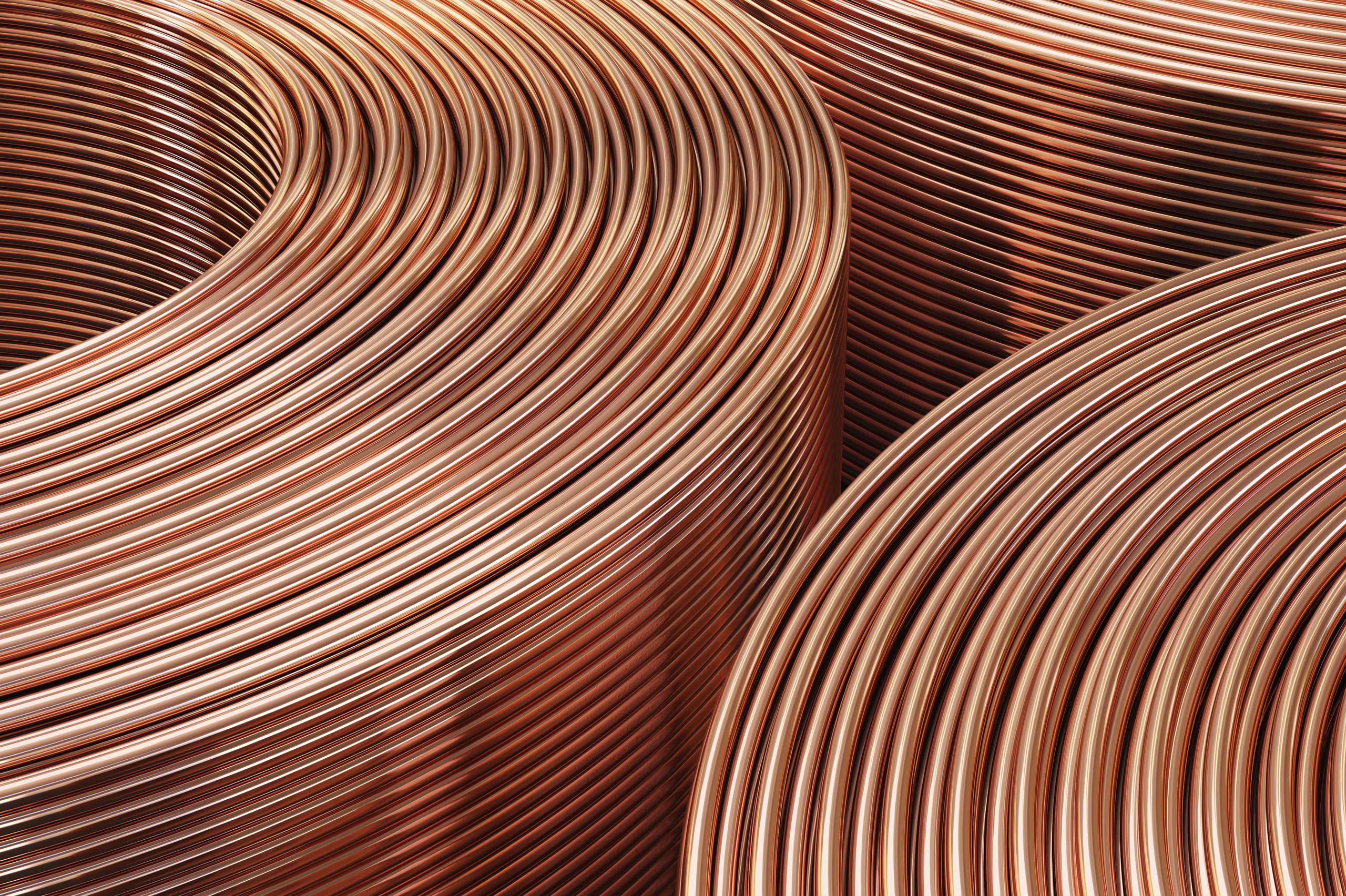 La imagen muestra rollos de cobre procesados en una fábrica.