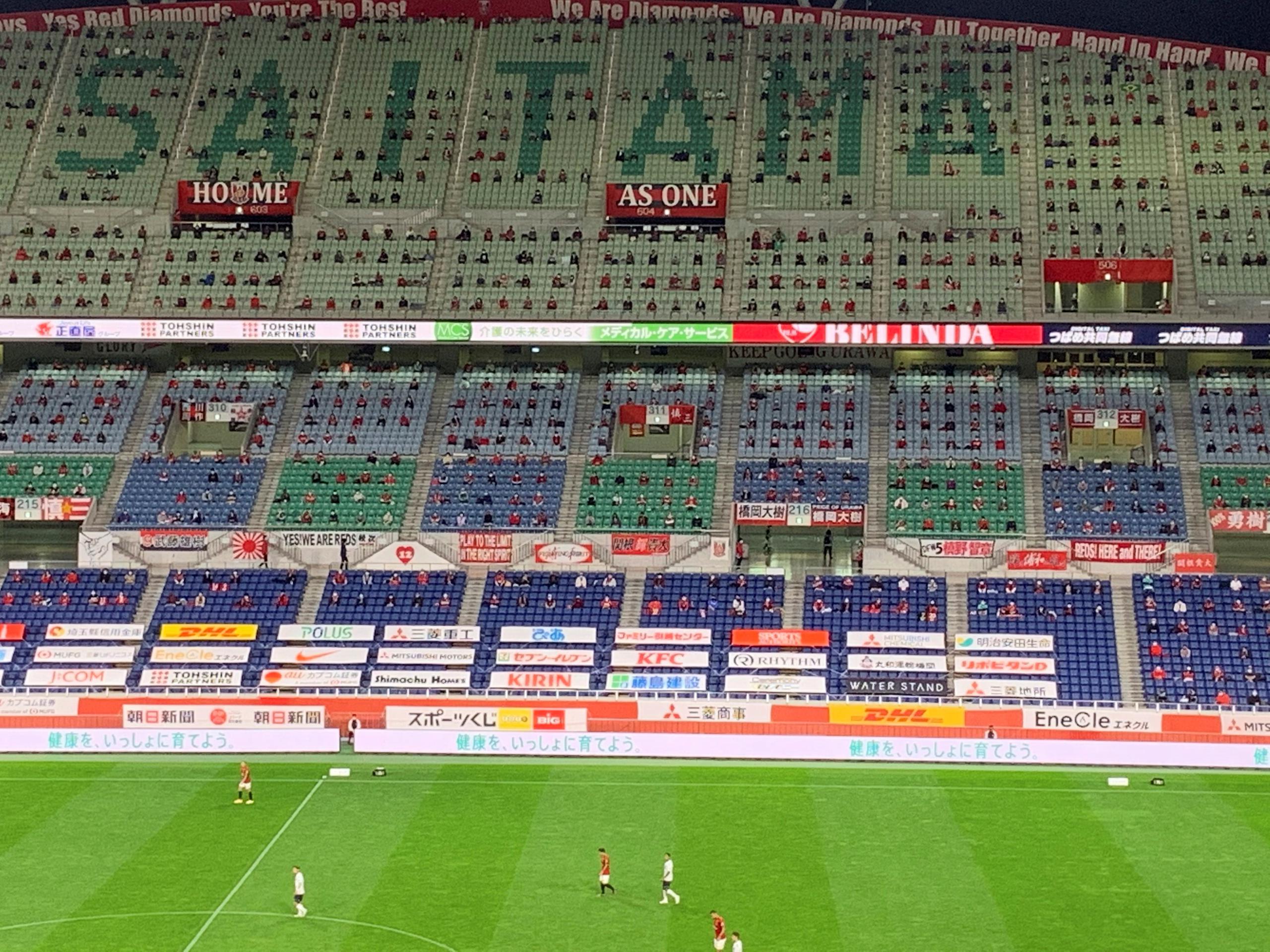 Unos 7,000 espectadores contemplan en silencio y con distancia social el partido Urawa Reds - Yokohama FC de la liga nipona de fútbol disputado este sábado en el Estadio de Saitama.