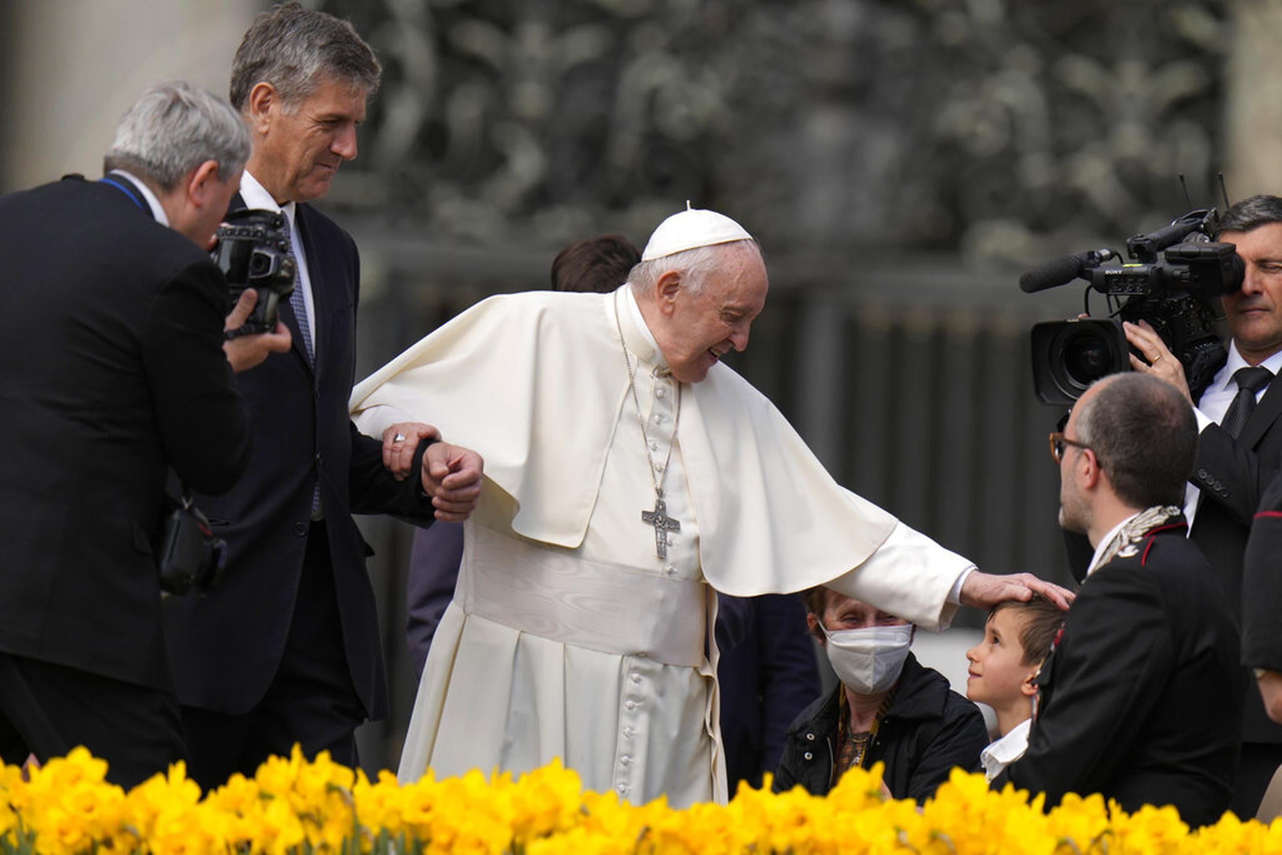 El papa Francisco acaricia la cabeza de un niño al final de su audiencia general semanal en la Plaza de San Pedro, en el Vaticano, el 20 de abril de 2022.