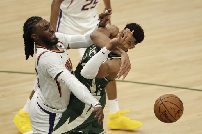 Giannis Antetokounmpo, a la izquierda, recibe una dura falta de parte de Jae Crowder, de los Suns, durante el tercer encuentro de la Serie Final de la NBA.