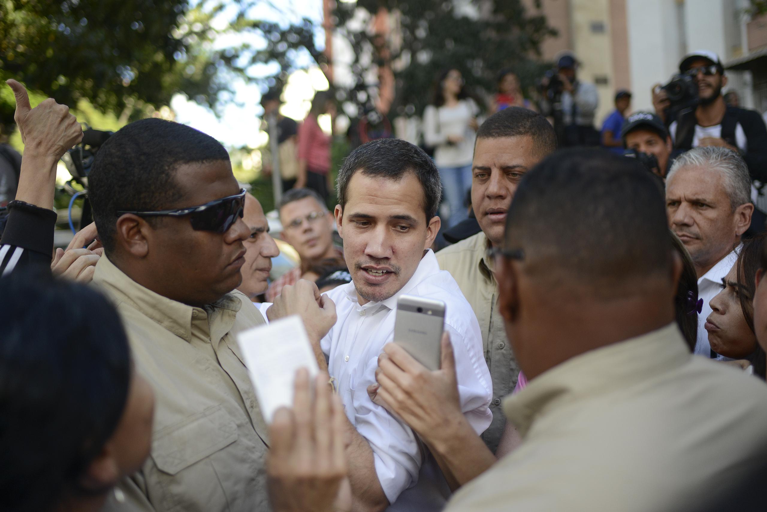 Guardaespaldas escoltan al líder opositor Juan Guaidó durante un evento en el que habló con sus simpatizantes en el barrio de Montalbán, en Caracas