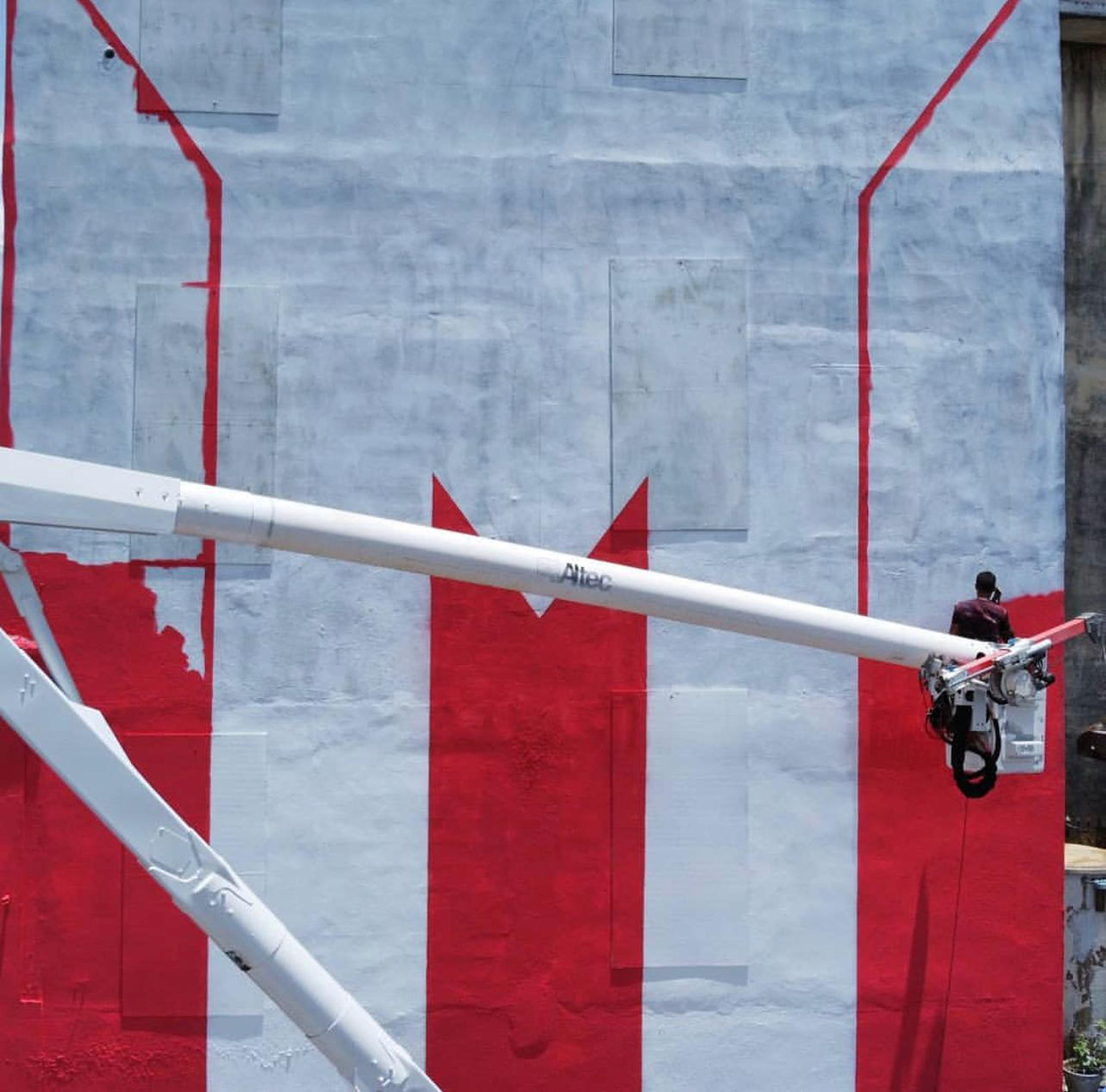 Héctor Collazo en el momento en que pinta una de las bandera de Puerto Rico del proyecto.