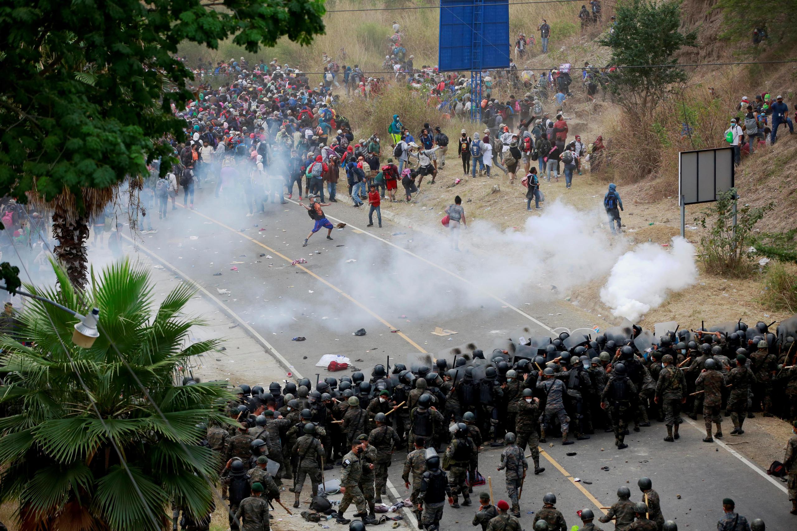 Soldados y policías guatemaltecos forman una barricada humana y lanzan gases lacrimógenos para detener a los migrantes hondureños que caminan por una carretera hoy, en Chiquimula (Guatemala).