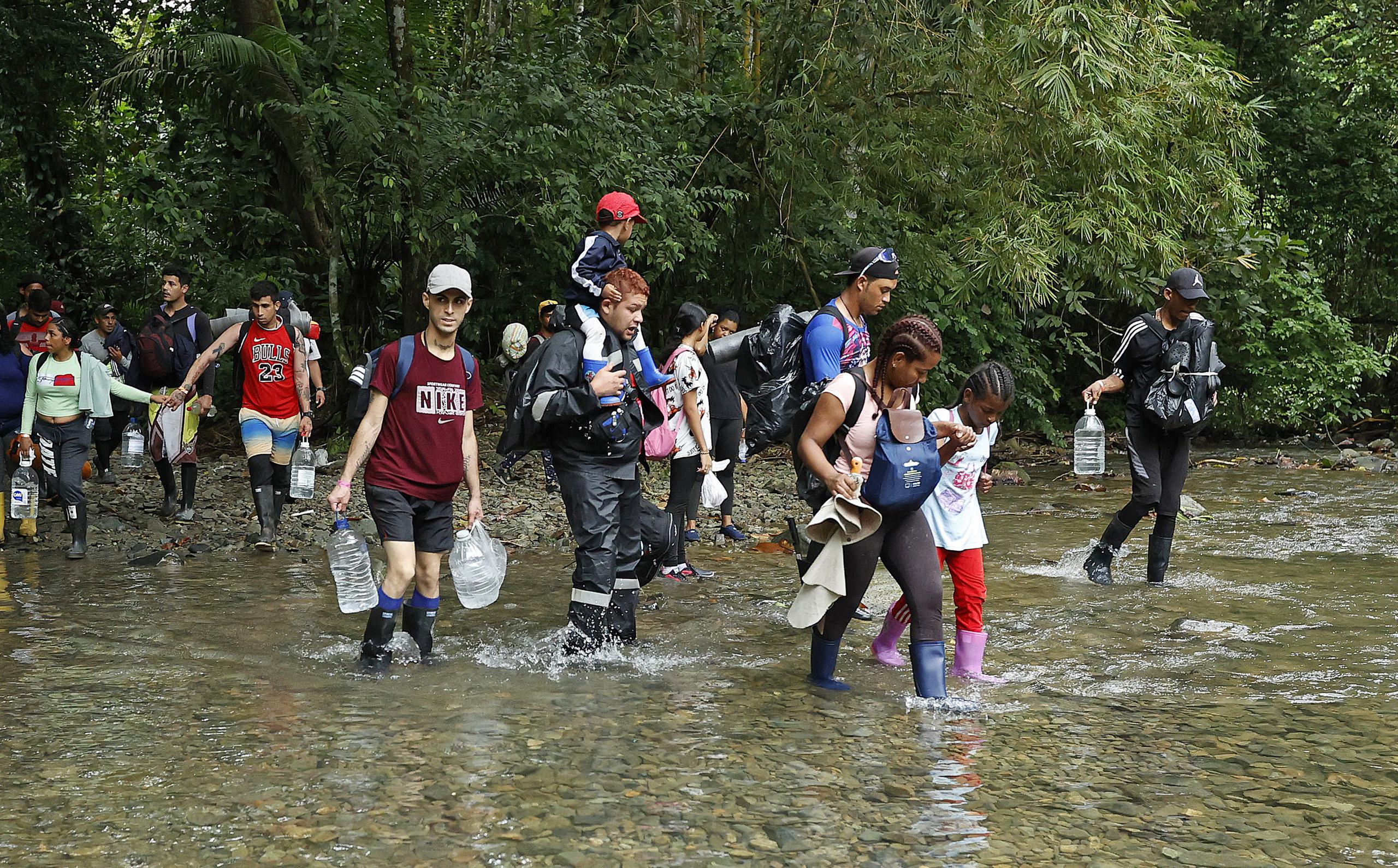 Migrantes atraviesan un río con la intención de llegar a Panamá a través del Tapón del Darién (Colombia). (EFE/ Mauricio Dueñas Castañeda)