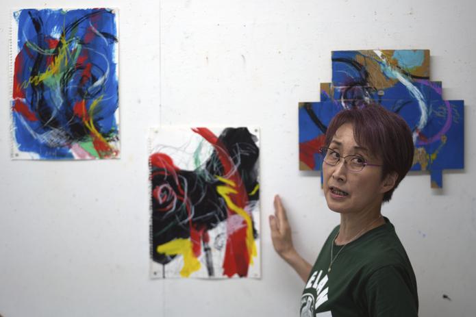 La artista japonesa Miwako Sakauchi presenta sus piezas para la exposición "Declaración del final de los Juegos Olímpicos" en Chiba cerca de Tokio.  (Foto AP/Eugene Hoshiko)