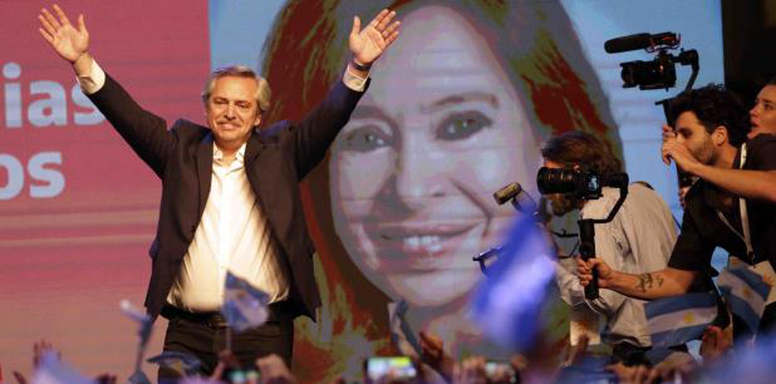 El peronista Alberto Fernández saluda a simpatizantes tras su triunfo electoral junto a una imagen gigante de su compañera de fórmula, la controversial expresidenta Cristina Fernández. (AP)