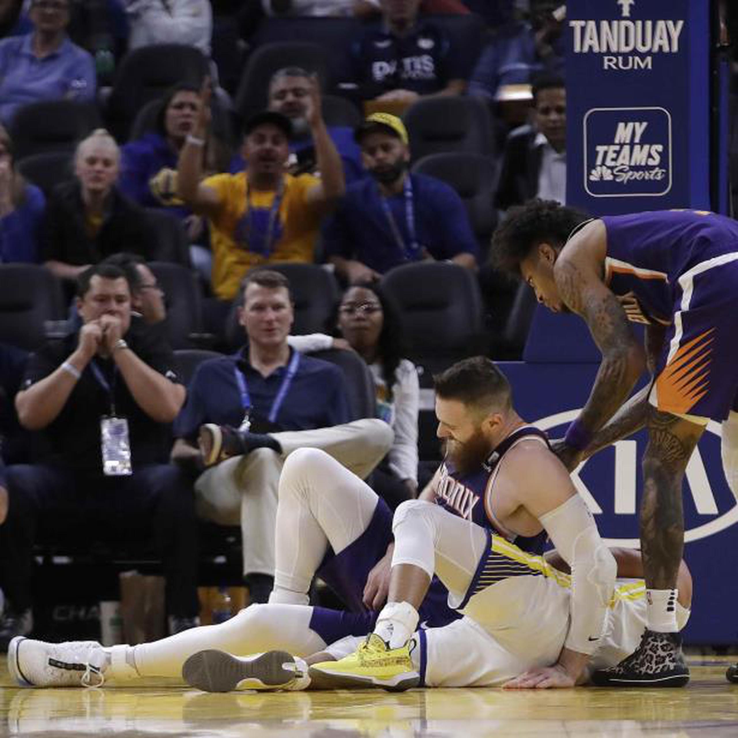 Aron Baynes, izquierda, de los Suns de Phoenix se levanta tras caer encima de Stephen Curry de los Warriors de Golden State, el miércoles 30 de octubre de 2019, en San Francisco. Curry salió de la cancha. (AP Foto/Ben Margot)