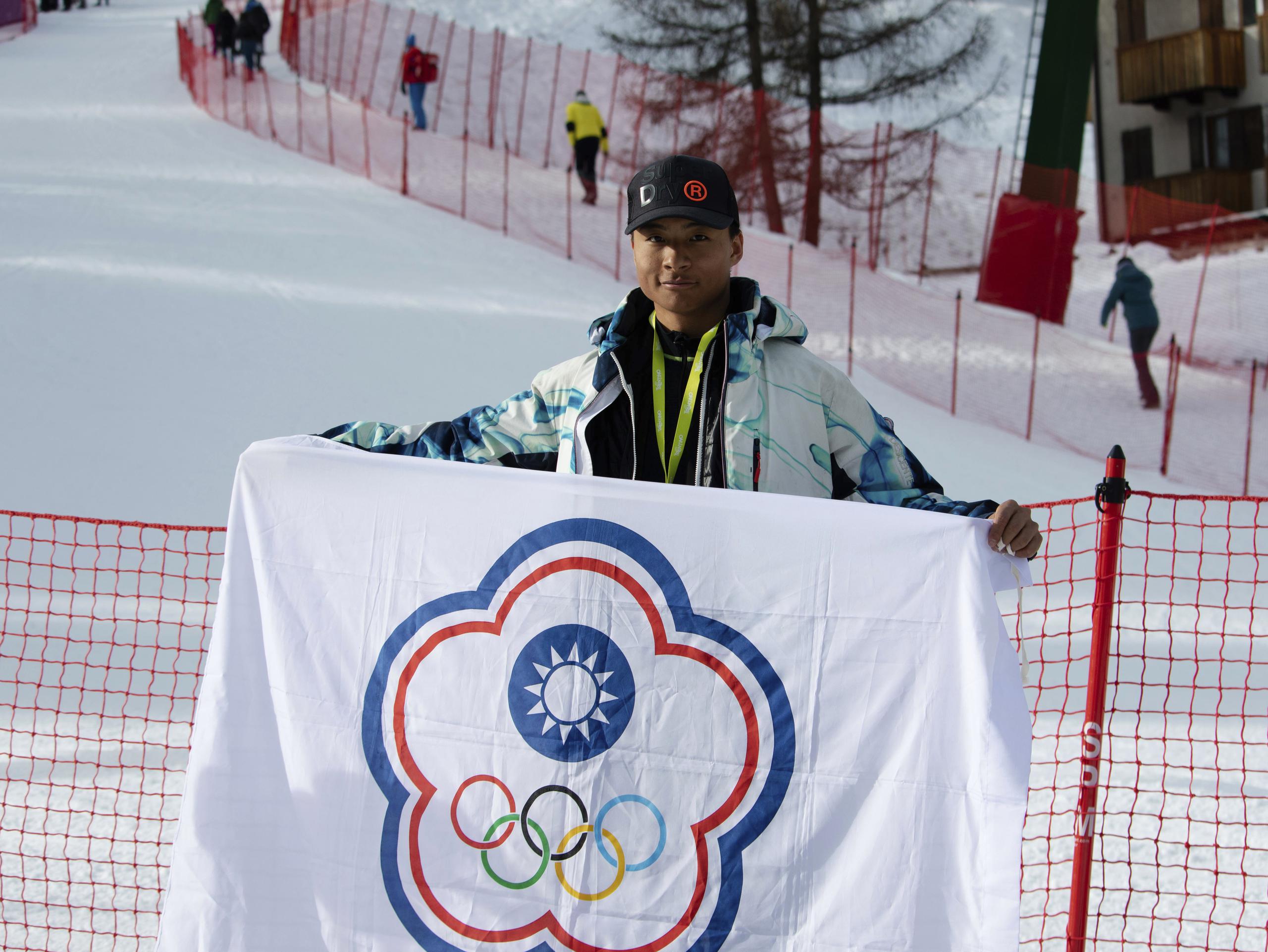 En esta foto proporcionada por Szollos Peter, el esquiador Ray Ho sostiene una bandera creada para representar a Taipéi China —el nombre bajo el cual Taiwán compite en competencias deportivas internacionales—, el 26 de febrero de 2019, en Italia.