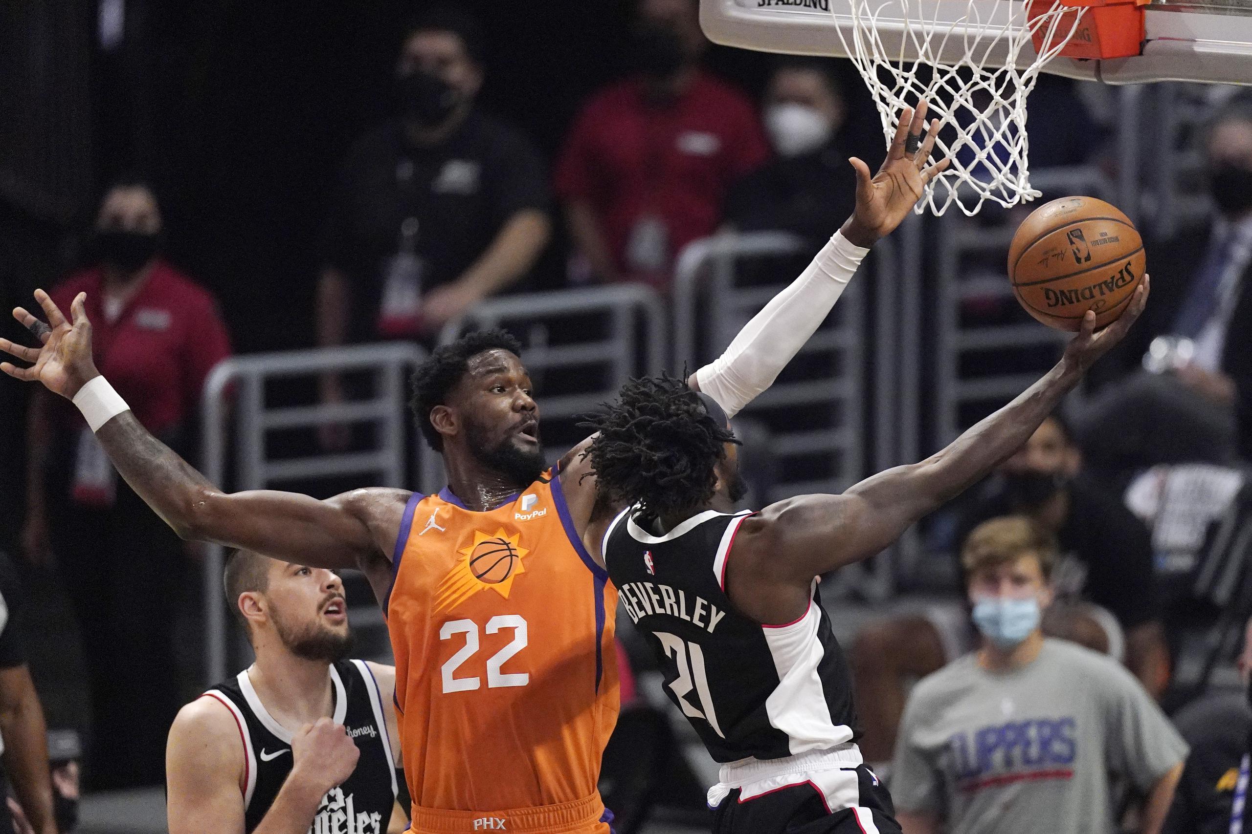 El pivote Deandre Ayton (22), de los Suns de Phoenix, intenta bloquear un tiro de Patrick Beverley, de los Clippers de Los Ángeles, en la primera mitad del tercer partido de la final de la Conferencia del Oeste de la NBA.