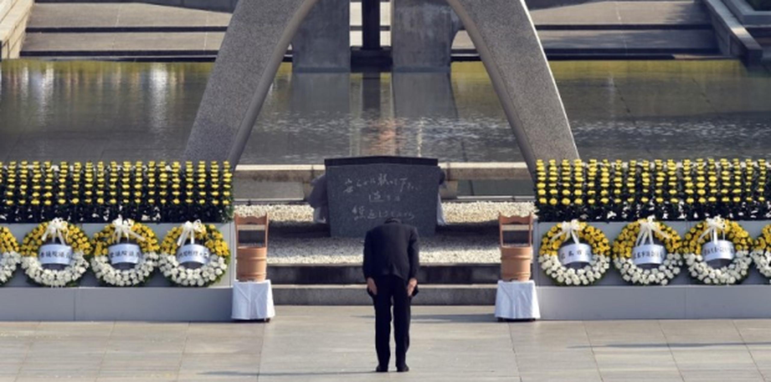 El primer ministro japonés, Shinzo Abe, realiza un acto de reverencia frente al monumento hubicado en un parque de Hiroshima dedicado a la paz situado cerca del epicentro del ataque de 1945. (AFP)