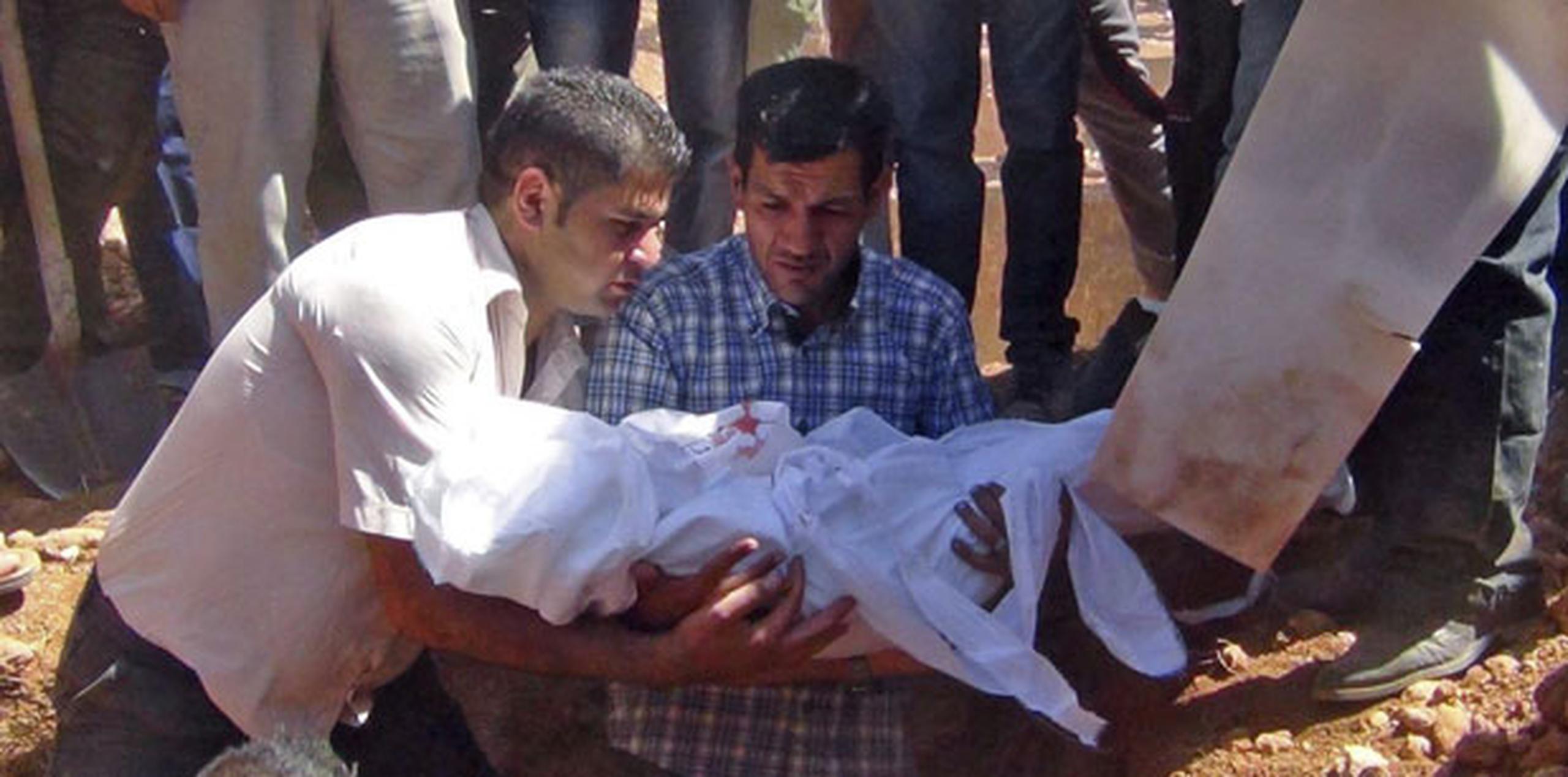 Abdulá Kurdi (centro), padre de Aylan Kurdi, el niño sirio-kurdo de tres años, durante el entierro de su hijo en Kobani, Siria. (EFE/Dicle News Agency)