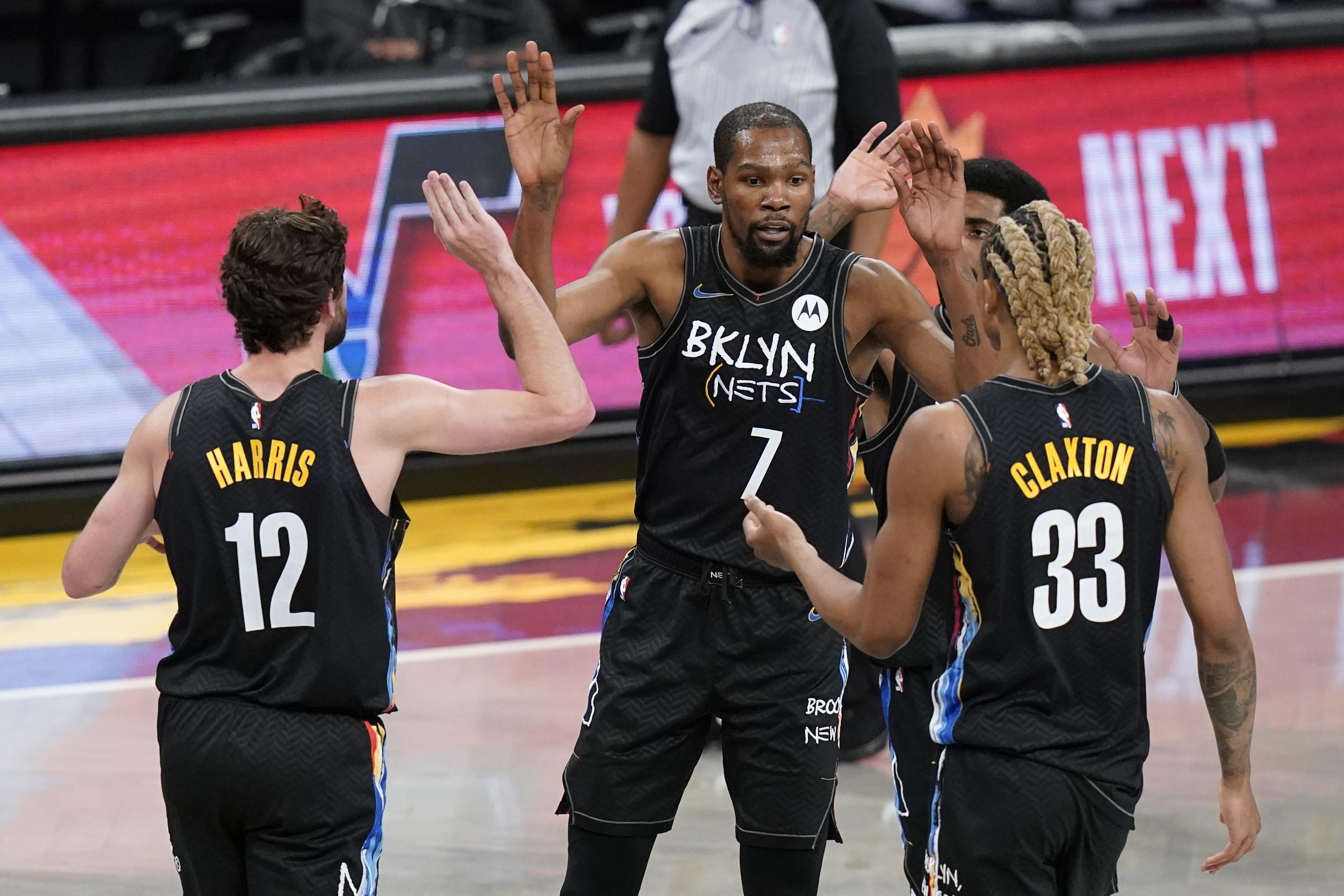 Kevin Durant celebra con sus compañeros de los Nets de Brooklyn Joe Harris y Nicolas Claxton en la primera mitad del juego ante los Pelicans de Nueva Orleans.