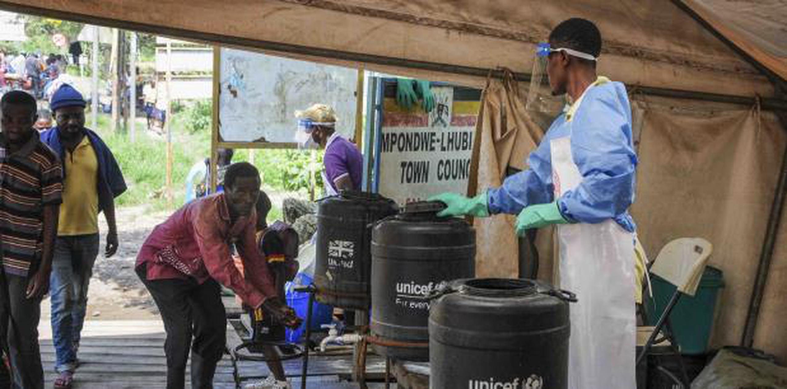 Las personas que vienen del Congo se lavan las manos con agua clorada para prevenir la propagación de la infección en el cruce de la frontera de Mpondwe con el Congo, en el oeste de Uganda. (AP / Ronald Kabuubi)