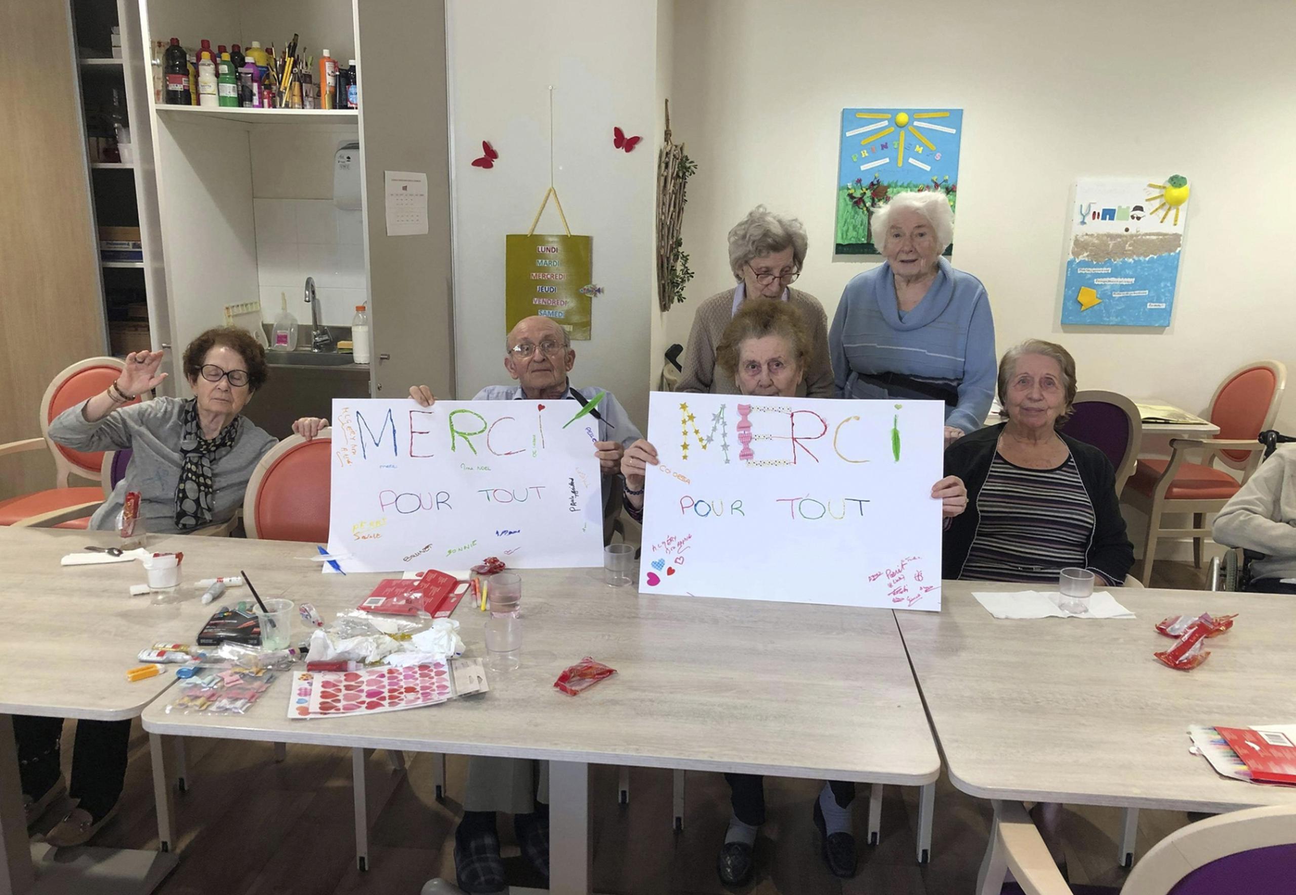 Residentes del geriátrico Vilanoba de las afueras de Lyon, Francia, muestran carteles que dicen "Gracias por todo" el 27 de abril del 2020.