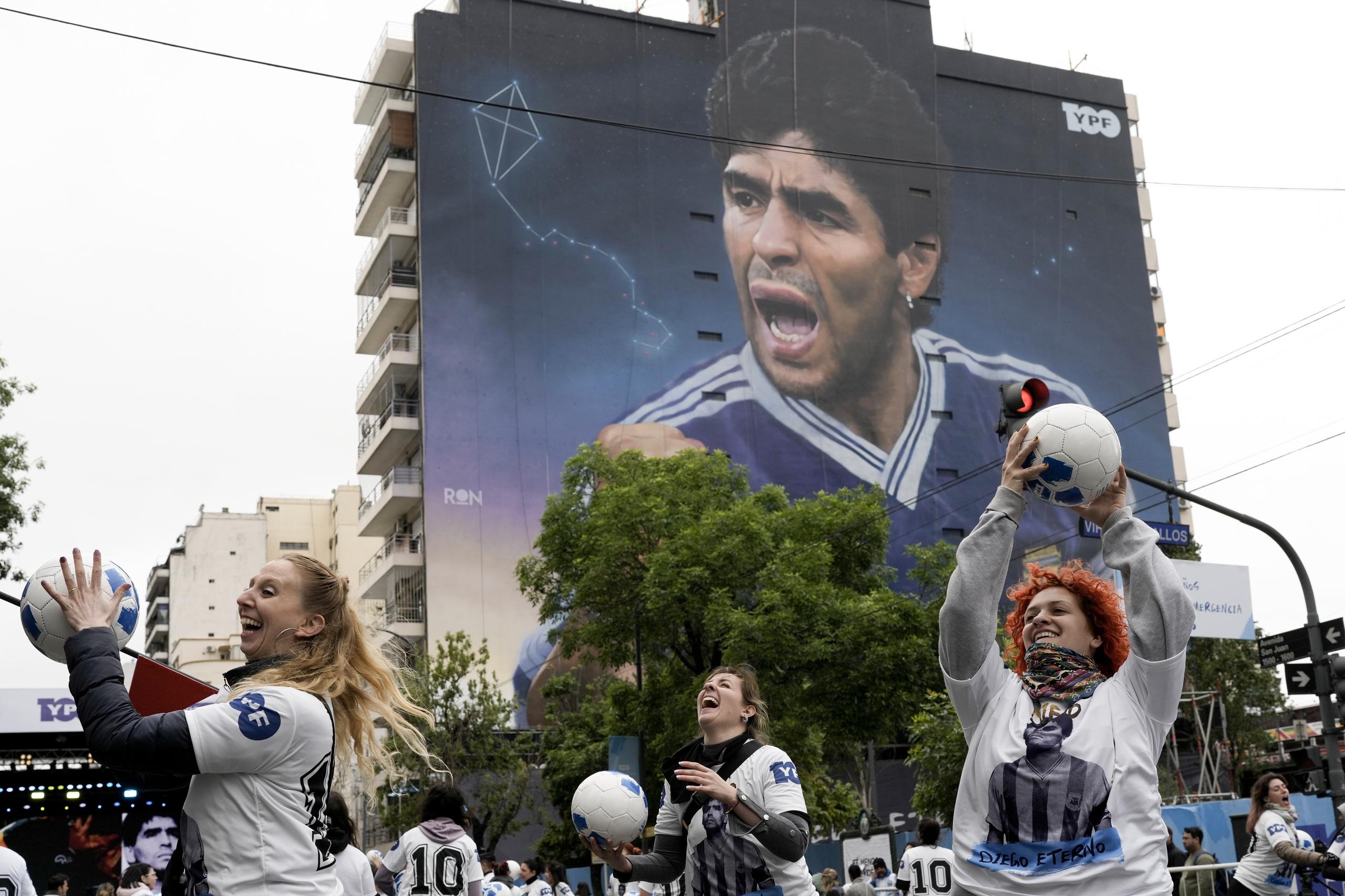 Un grupo de mujeres juegan con balones durante la inauguración del mural de Diego Maradona del artista Martín Ron en Buenos Aires, Argentina, el domingo 30 de octubre de 2022. (AP Foto/Rodrigo Abd)