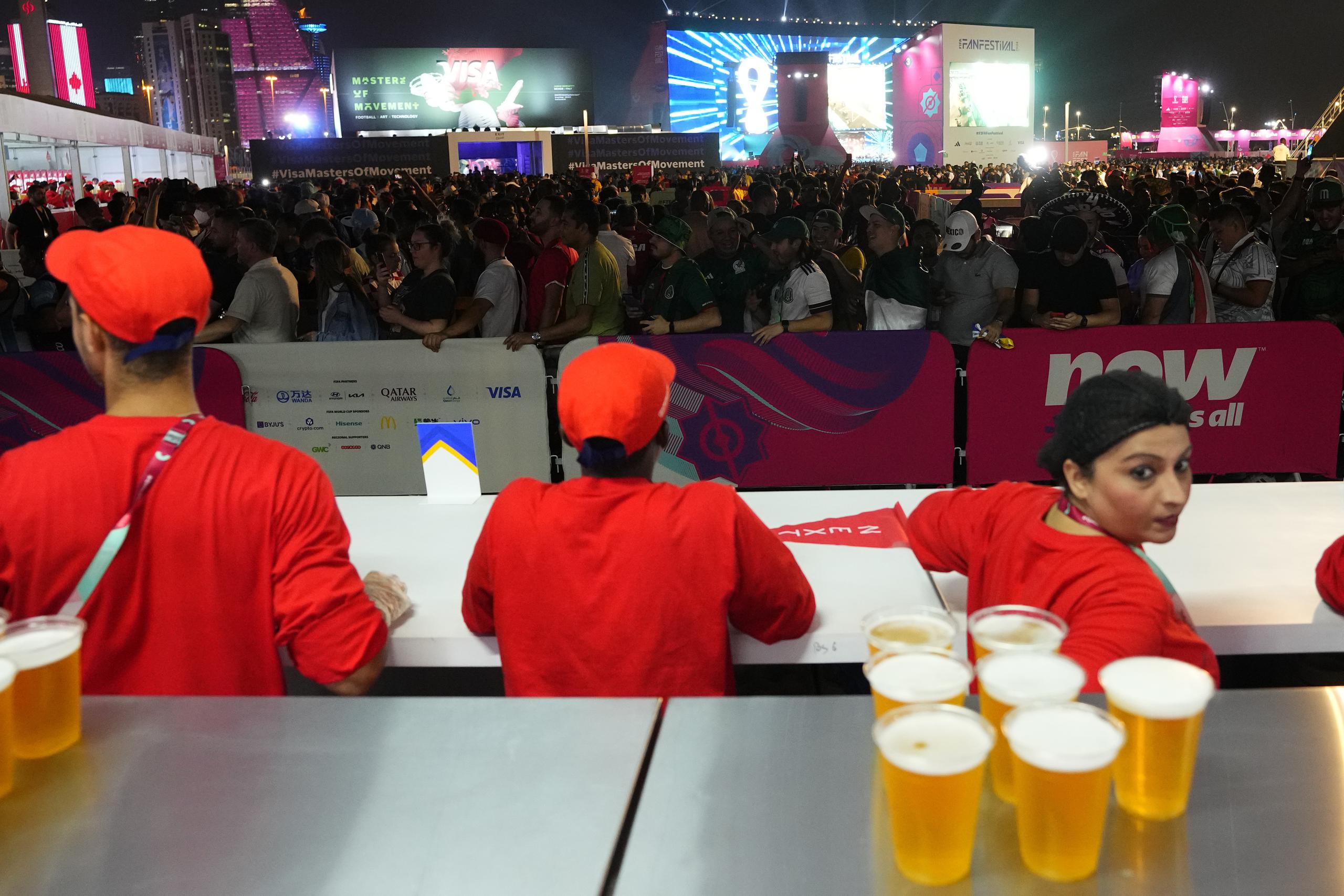 Aficionados forman fila para comprar cerveza en una zona destinada para ellos en Doha.