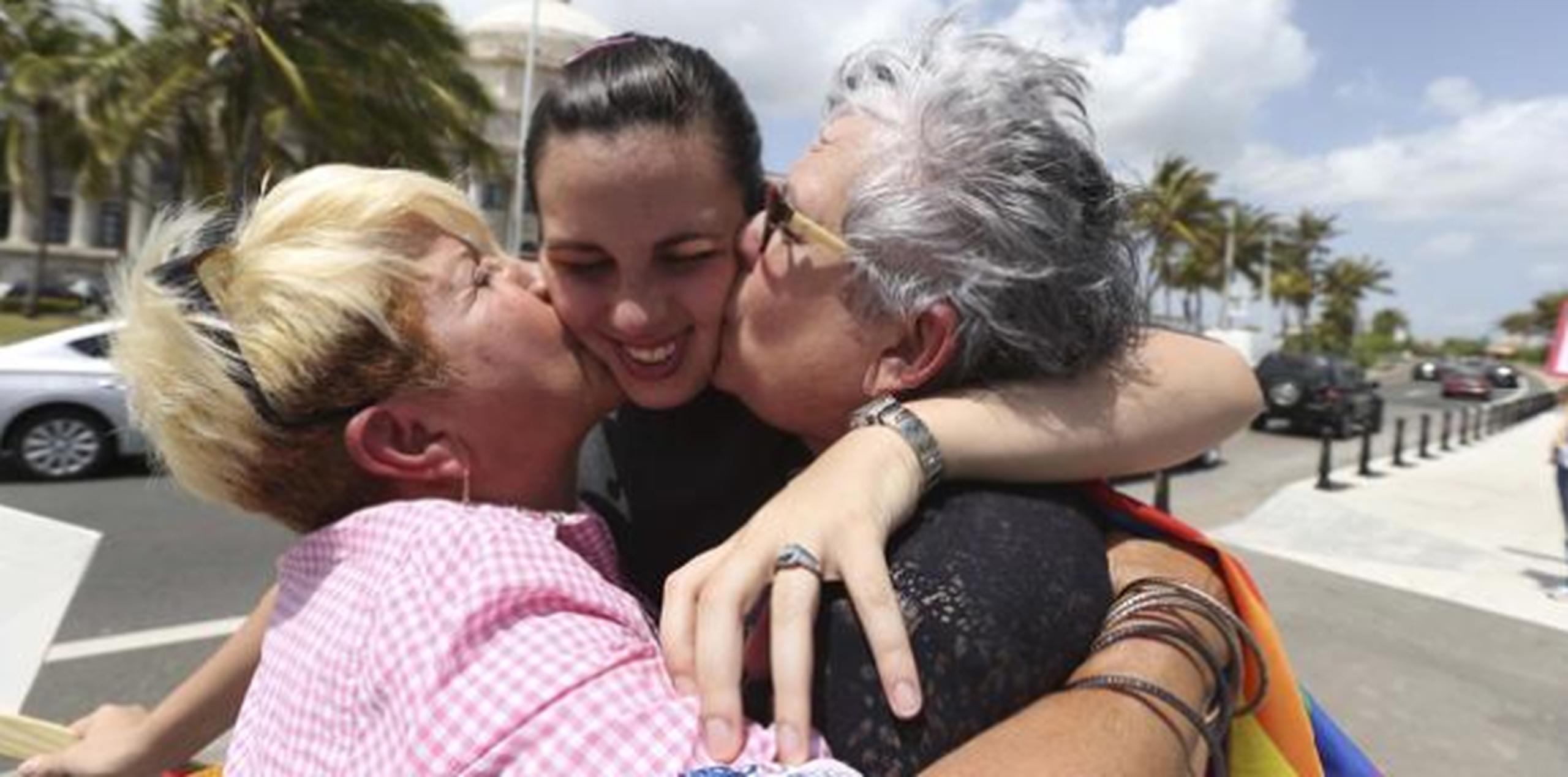 Ada Álvarez, activista contra el maltrato en el noviazgo, recibe besos de su madre Ada Conde y la esposa de su madre, Ivonne. (Archivo)