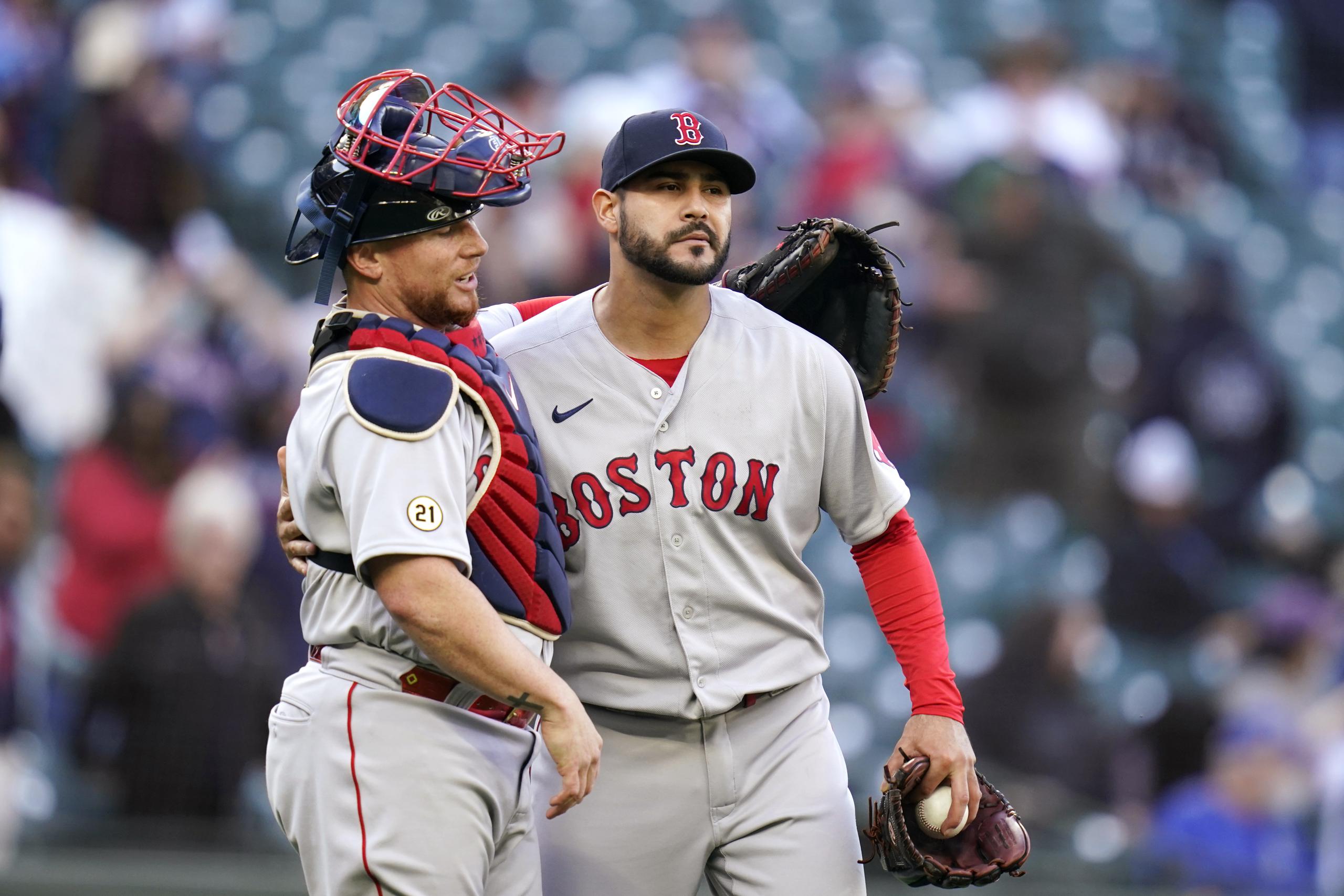 Boston Red Sox catcher Christian Vazquez, left, throws his arm around closing pitcher Martin Perez after the team beat the Seattle Mariners in a baseball game Wednesday, Sept. 15, 2021, in Seattle. The Red Sox won 9-4 in 10 innings. (AP Photo/Elaine Thompson)