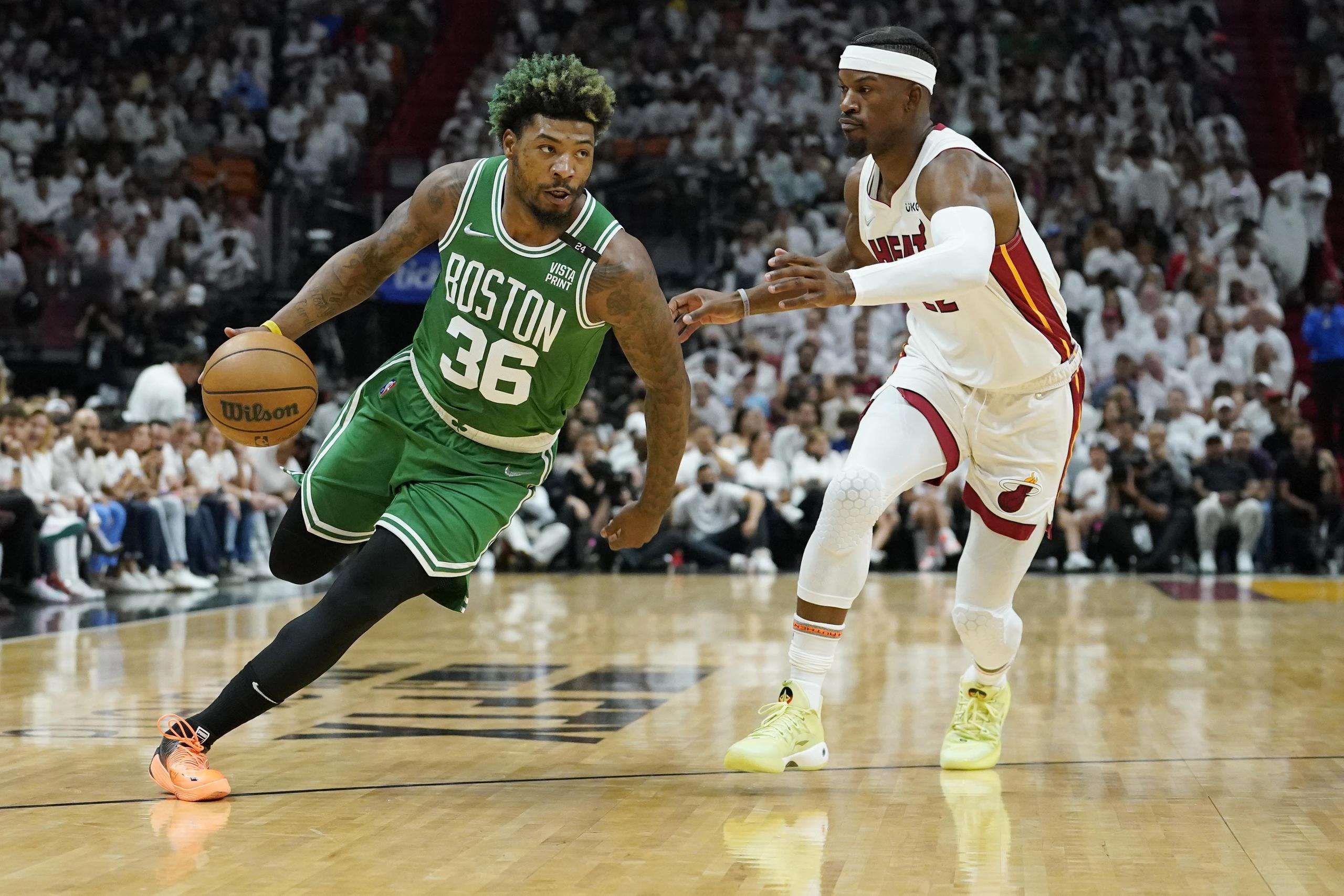 El escolta de los Celtics de Boston , Marcus Smart (36), trata de avanzar con el balón mientras Jimmy Butler, del Heat de Miami le sigue los pasos de cerca.
