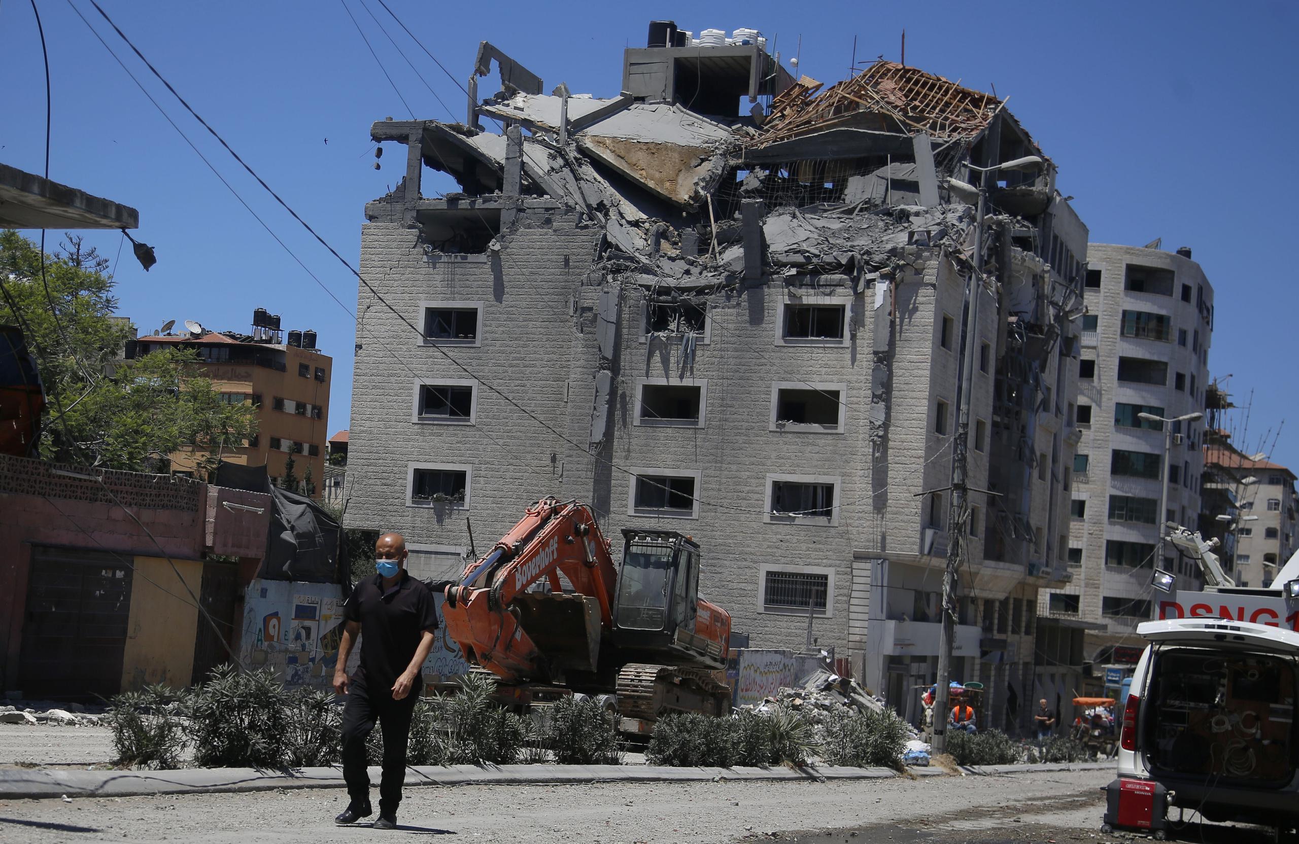 Un palestino pasa junto a un edificio golpeado por un ataque israelí en Ciudad de Gaza.