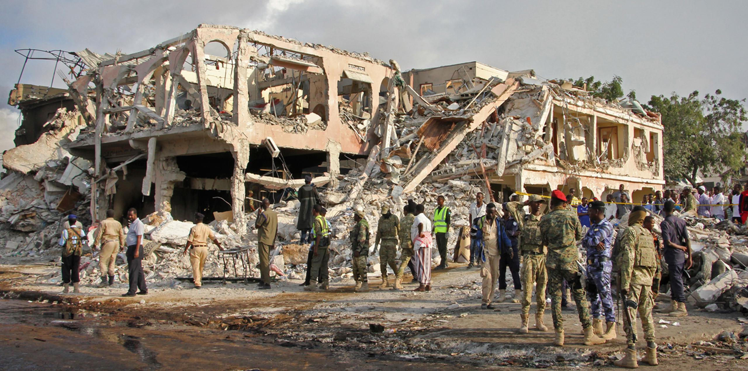 Fuerzas de seguridad somalíes y otras personas buscan cadáveres cerca del lugar donde ocurrió un atentado el sábado, en Mogadiscio, Somalia. (AP)