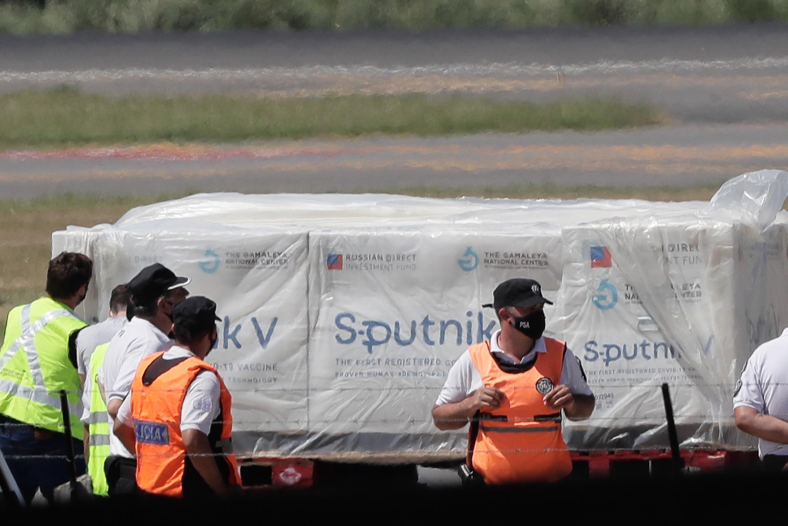 Operarios descargan contenedores de la vacuna rusa Sputnik V en el Aeropuerto de Ezeiza en Buenos Aires.