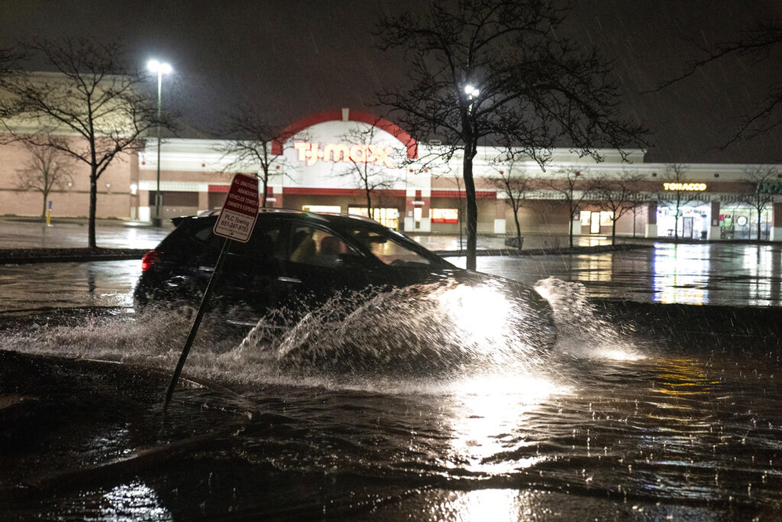 Un vehículo atraviesa un estacionamiento inundado en University Avenue en St. Paul, Minnesota, el 11 de mayo de 2022.