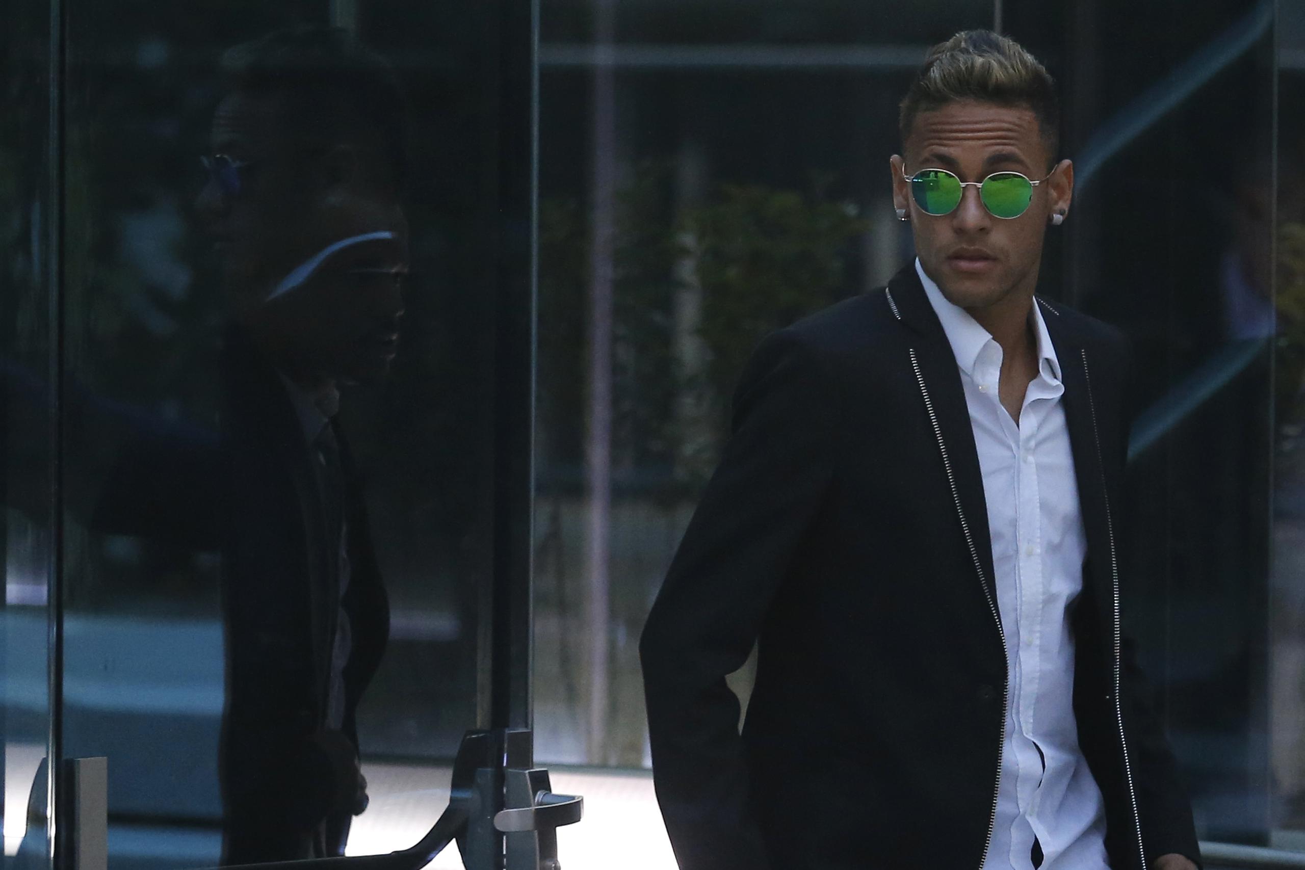 El delantero brasileño Neymar se retira de un juzgado en Madrid tras una indagatoria por irregularidades por su traspaso al Barcelona.
