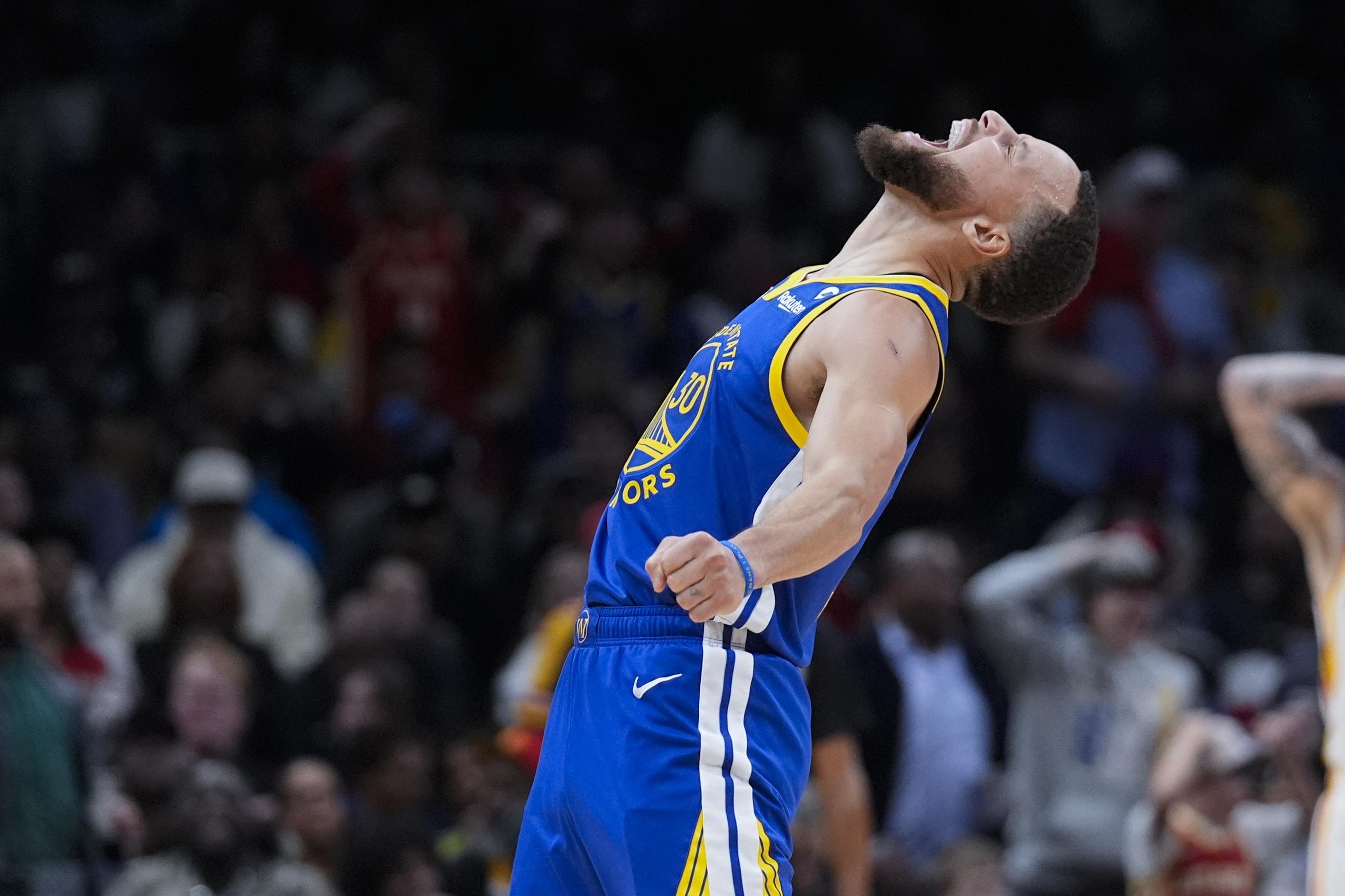 El escolta de los Warriors de Golden State, Stephen Curry, reacciona después de anotar en la segunda mitad del partido de baloncesto de la NBA contra los Hawks de Atlanta.