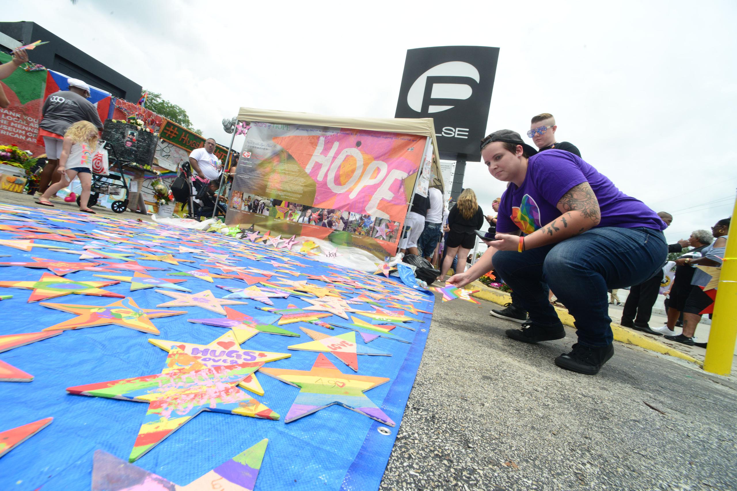 Imagen de archivo que muestra a varias personas colocando estrellas con mensajes escritos a las 49 personas que perdieron la vida en la matanza perpetrada en la discoteca gay Pulse. EFE/Gerardo Mora
