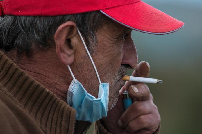 Un hombre fuma un cigarro con la mascarilla bajada, en una imagen de archivo. EFE/ Brais Lorenzo
