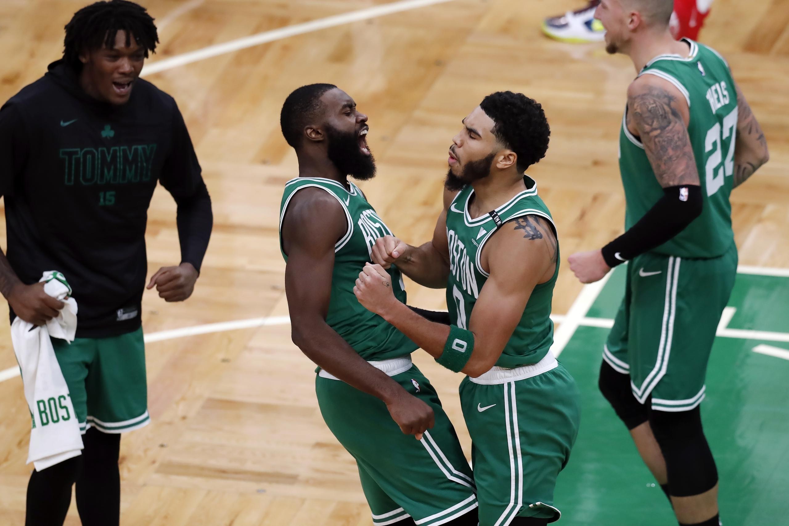 Jayson Tatum (derecha), de los Celtics de Boston, festeja con Jaylen Brown, tras lograr el enceste de la ventaja sobre los Bucks de Milwaukee.