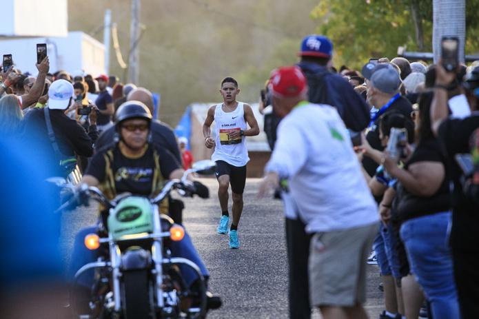 El coameño Arnaldo Martínez Rey corre hacia la meta del medio maratón, donde cientos de locales y visitantes del pueblo lo aplaudían por completar la ruta del evento.