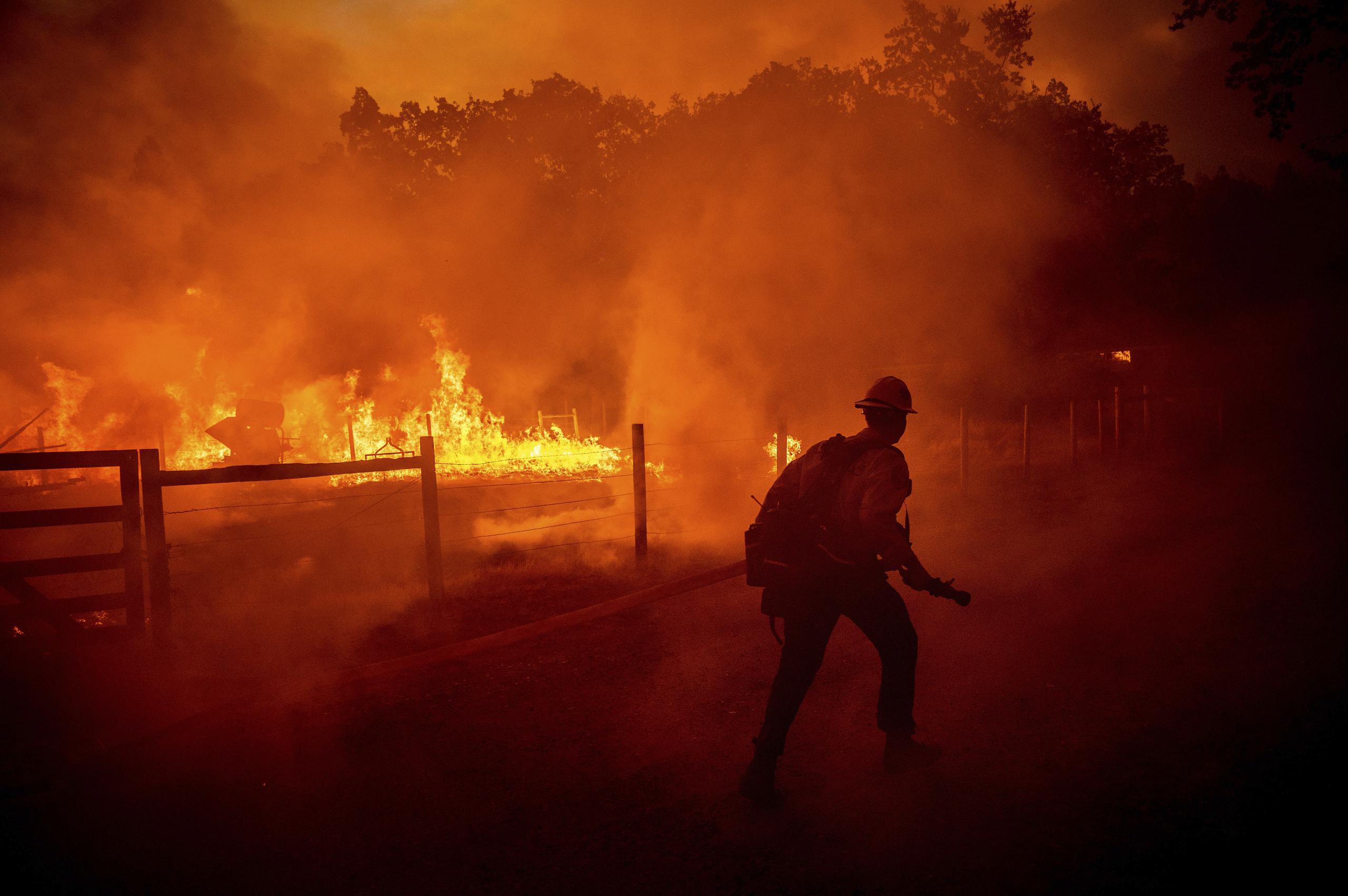 Un bombero intenta apagar las llamas de un incendio forestal, el 22 de julio de 2022, en Darrah Road, en el condado Mariposa, California. (AP Foto/Noah Berger, Archivo)